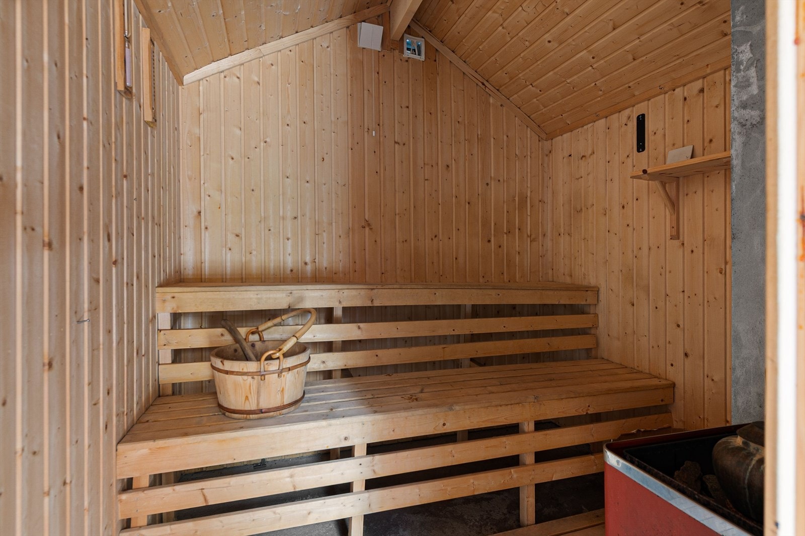 Romslig badstue med trepanel og benker gir mulighet for avslapning og varme. Galleribilde