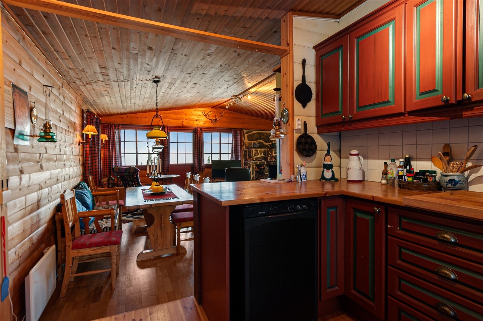 Kjøkkenet har profilerte fronter og en benkeplate av heltre, med ventilator som leder avtrekk ut (kilde: tilstandsrapport). Galleribilde