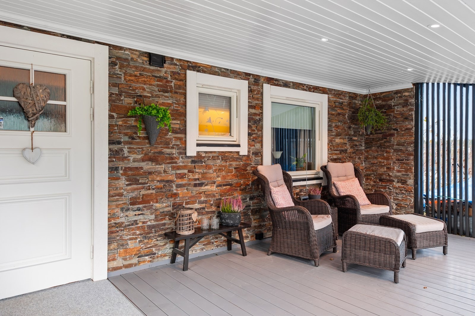 Hyggelig inngangsveranda med steinbelagt vegg og tregulv. Galleribilde