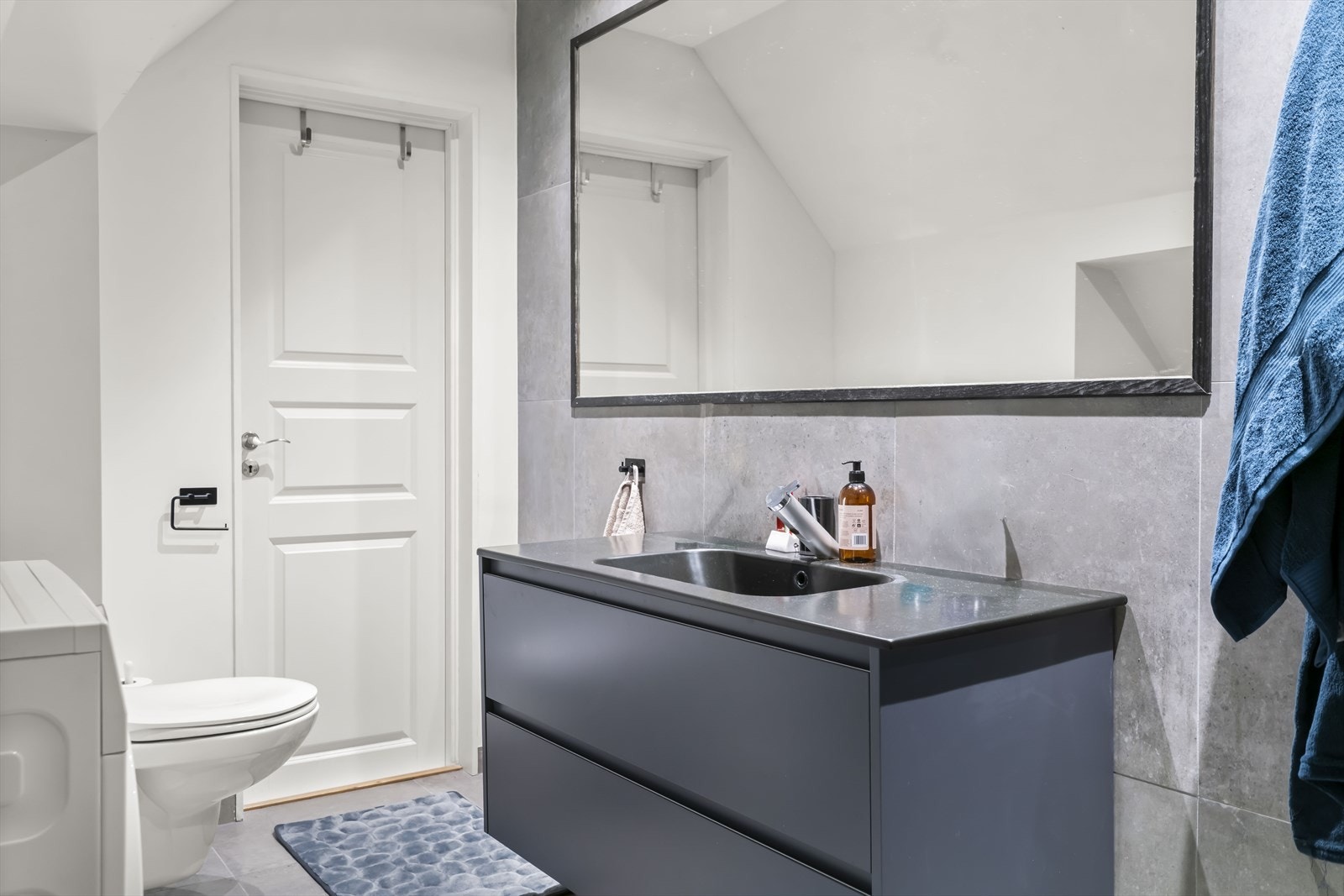 Rommet har innredning med nedfelt servant, veggmontert toalett, dusjvegger/hjørne og opplegg for vaskemaskin. Galleribilde