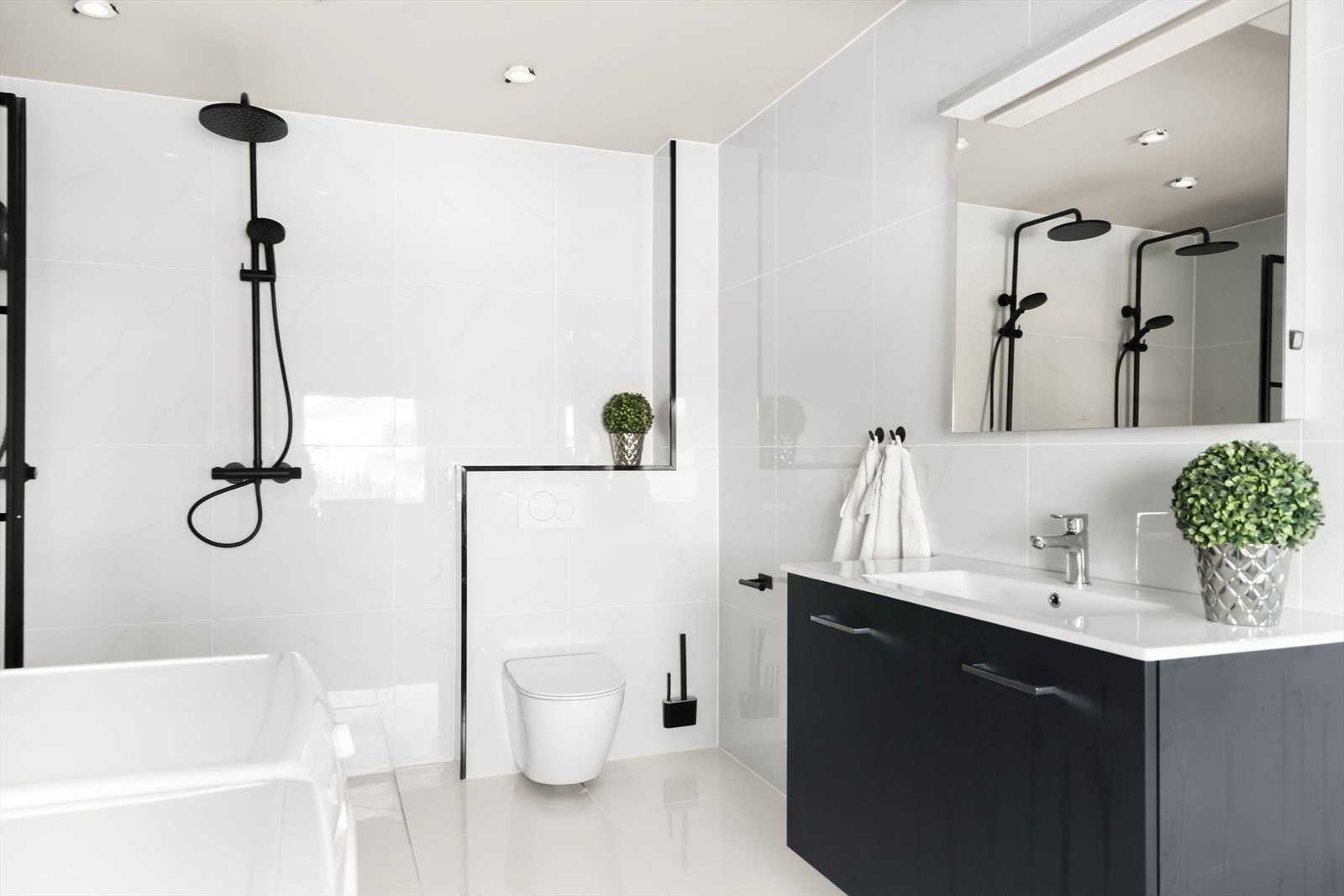 Videre har badet servant med skuffer, speil med belysning og vegghengt toalett. Galleribilde