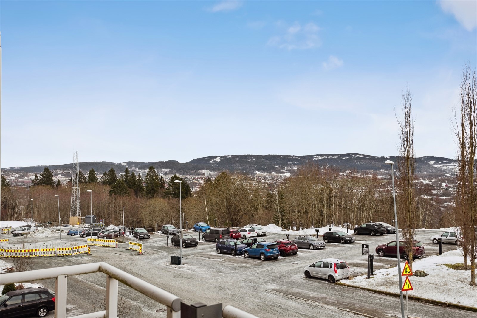 Utsikten fra balkongen gir oversikt over parkeringsplassen og nærliggende grøntområder. Galleribilde