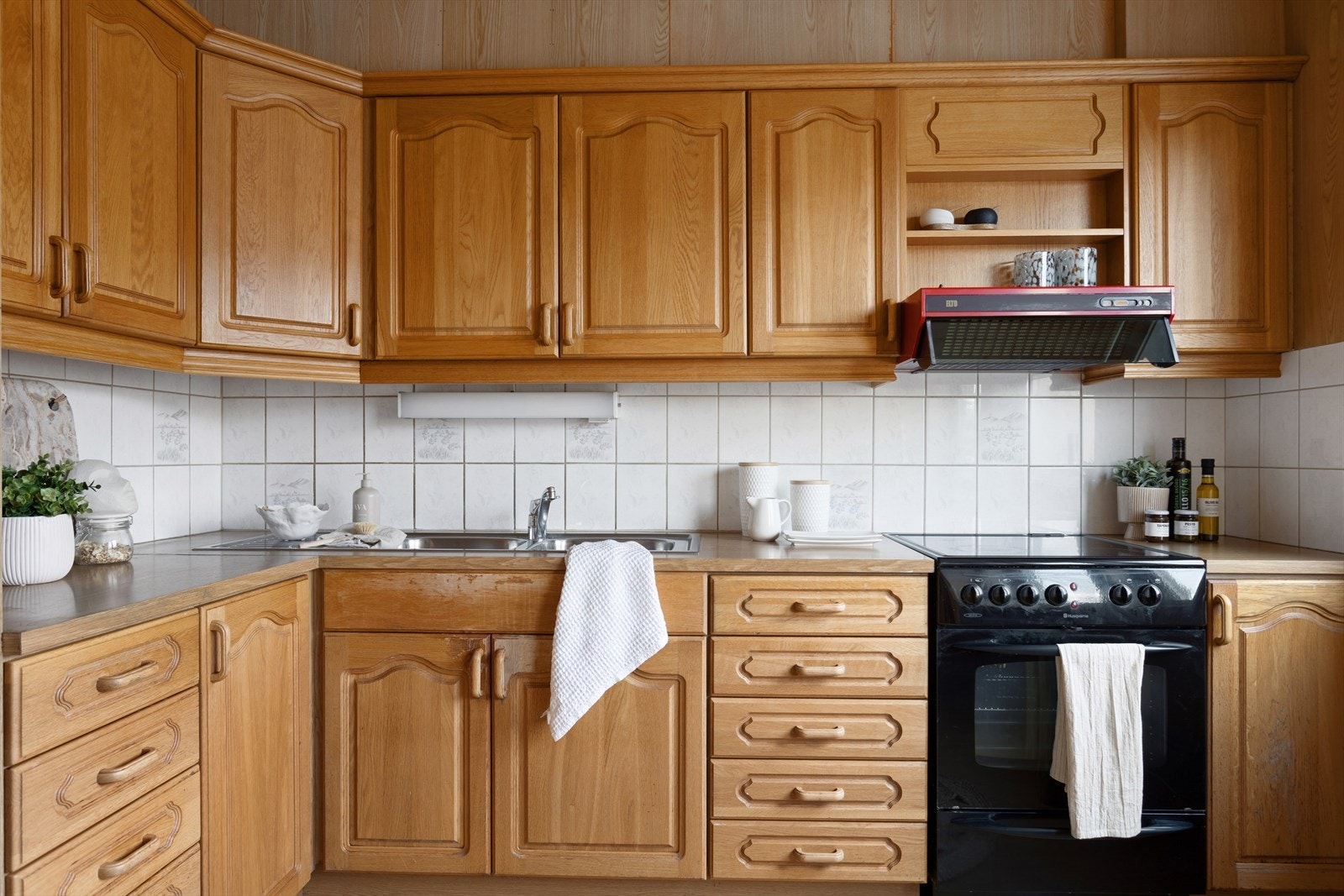 Trefronter og fliser gir kjøkkenet et klassisk preg, med mekanisk avtrekk. Galleribilde