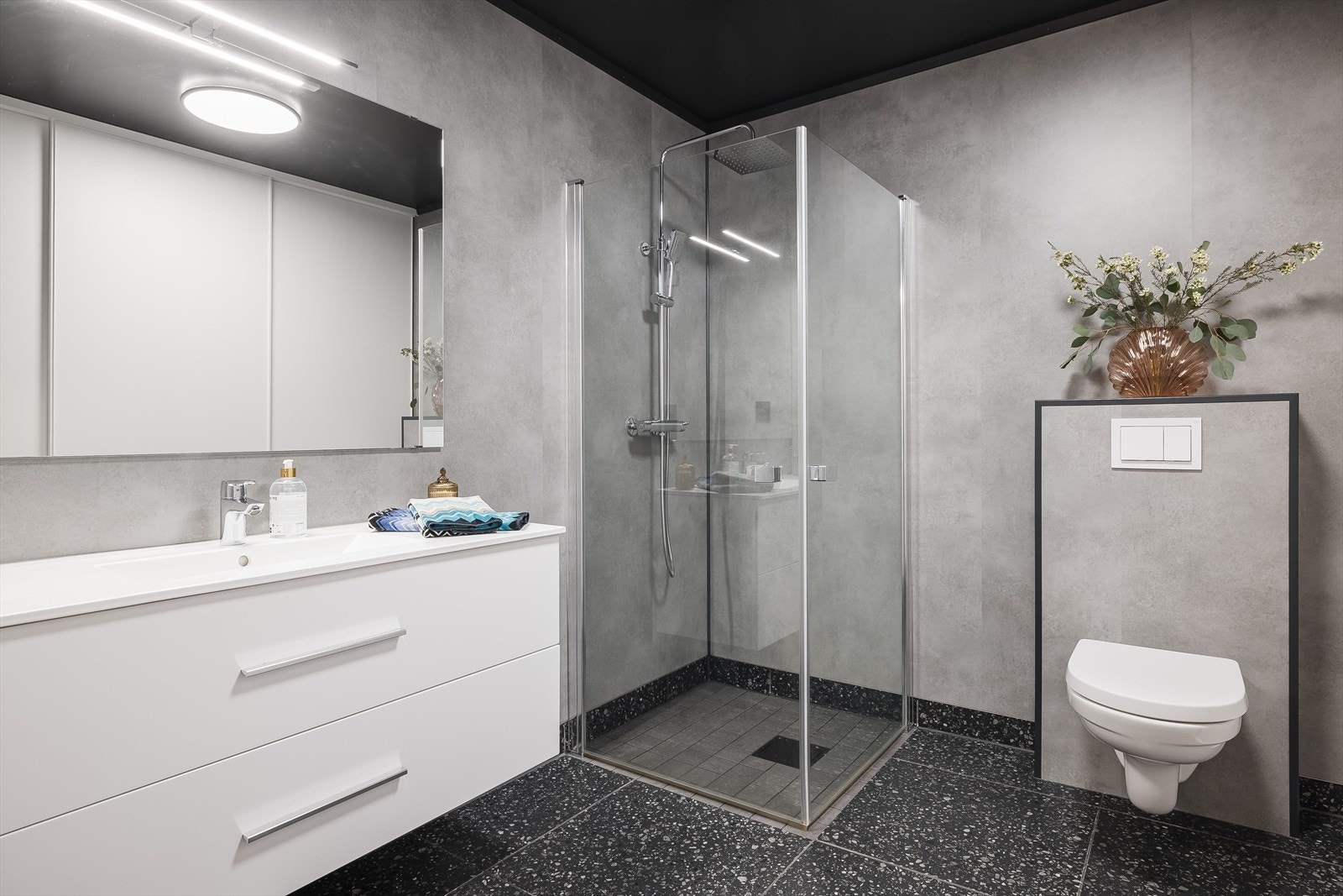 Badet er av god størrelse og har baderomsplater på veggene, plater i himlingen og fliser på gulvet med varmekabler. Galleribilde