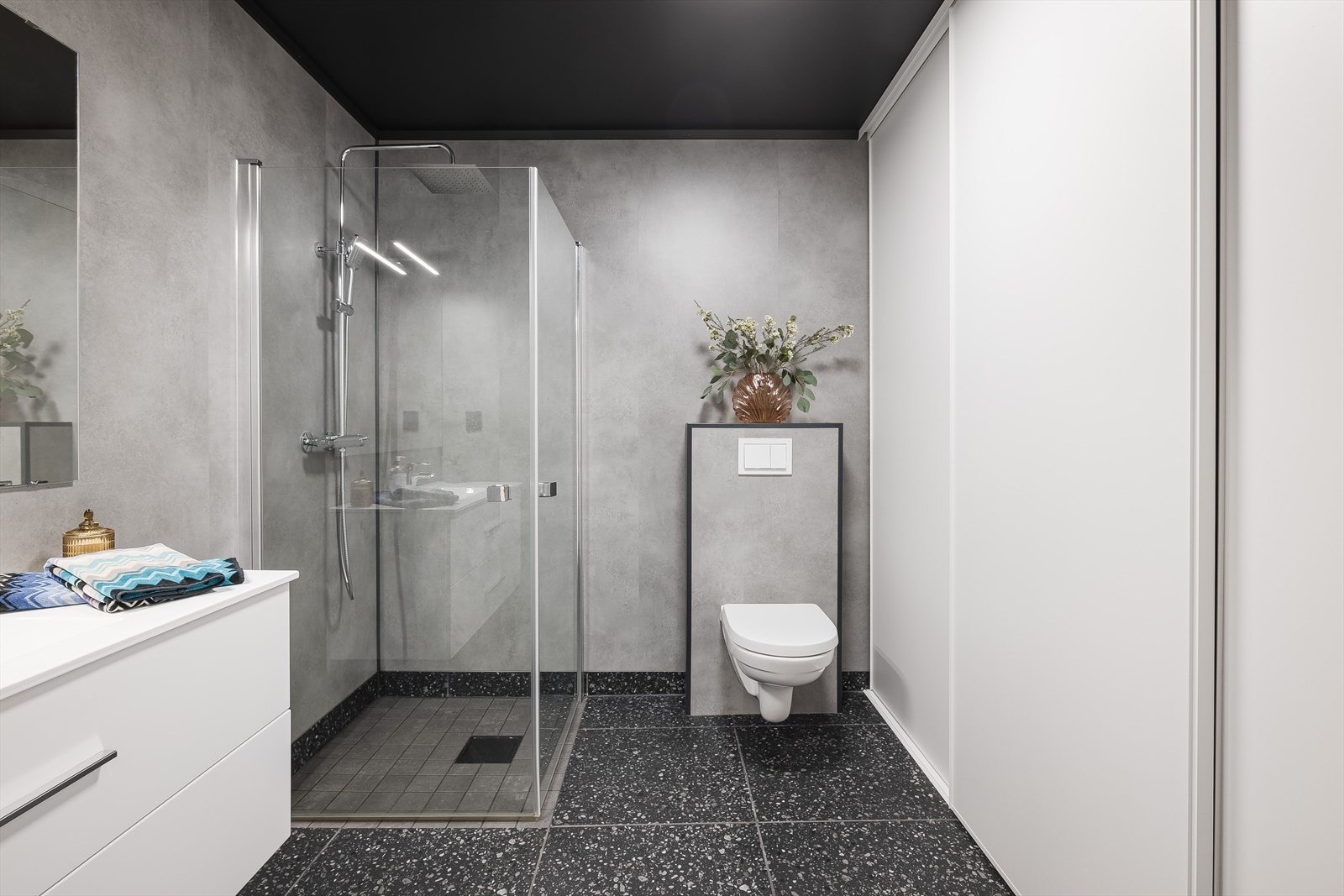 Rommet er praktisk delt av med den store skyvedørsgarderoben. Der er det lagt opp for vaskemaskin og tørketrommel. Ellers er det praktisk innredning med mye oppbevaring som gjør klesvasken til en lek. Galleribilde