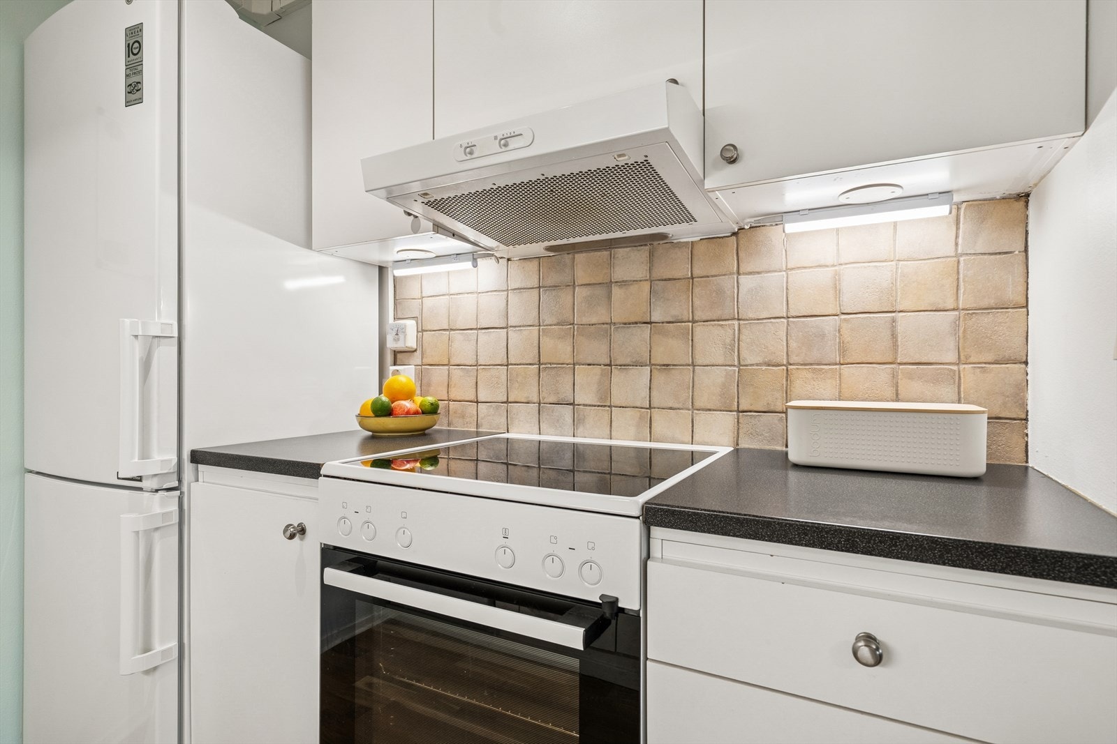 Det er plass for frittstående hvitevarer (medfølger ikke) og over komfyrplassen er det kjøkkenventilator med utkast via luftekanal Galleribilde