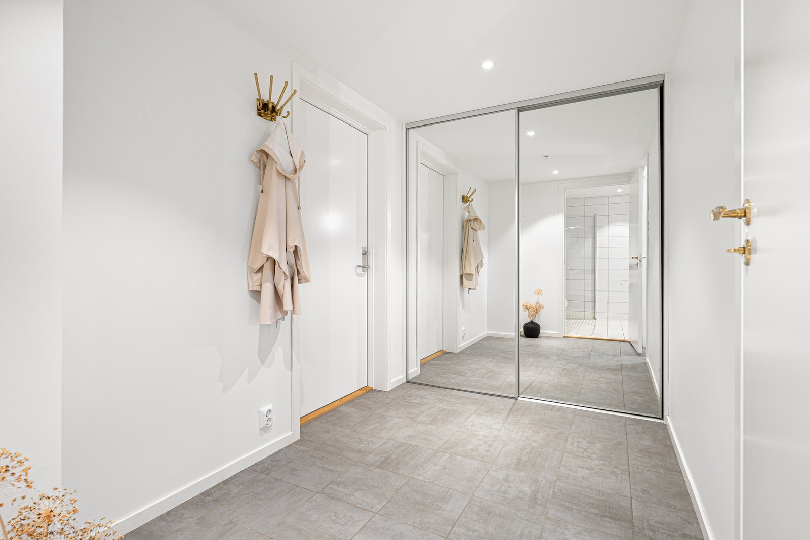 Den romslige gangen er påkostet med flislagt gulv og en dyp, praktisk skyvedørsgarderobe som gir svært god oppbevaringsplass. Galleribilde