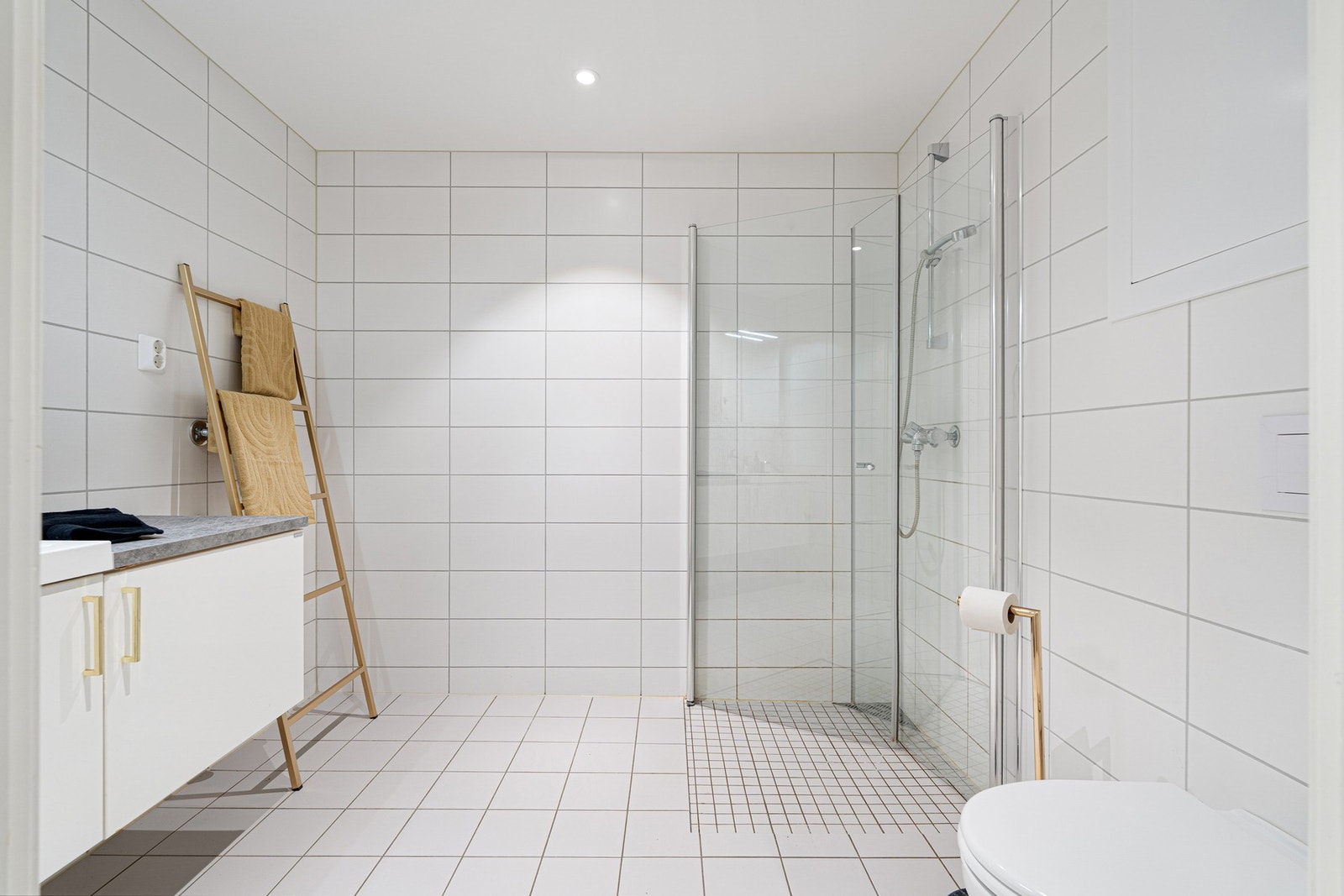 Badet fremstår lekkert og delikat, med fliser på veggene og et romslig dusjhjørne. Galleribilde