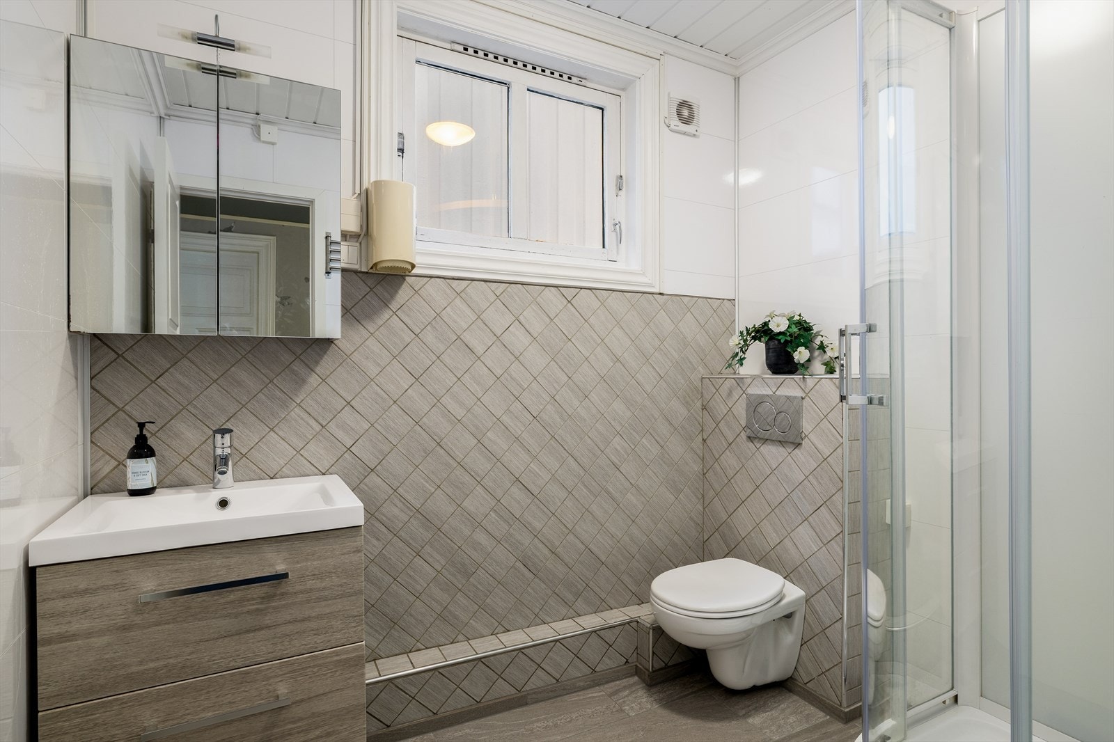 Bad med vegghengt toalett, baderomsinnredning i nedfelt servant og dusjkabinett (2024) Galleribilde