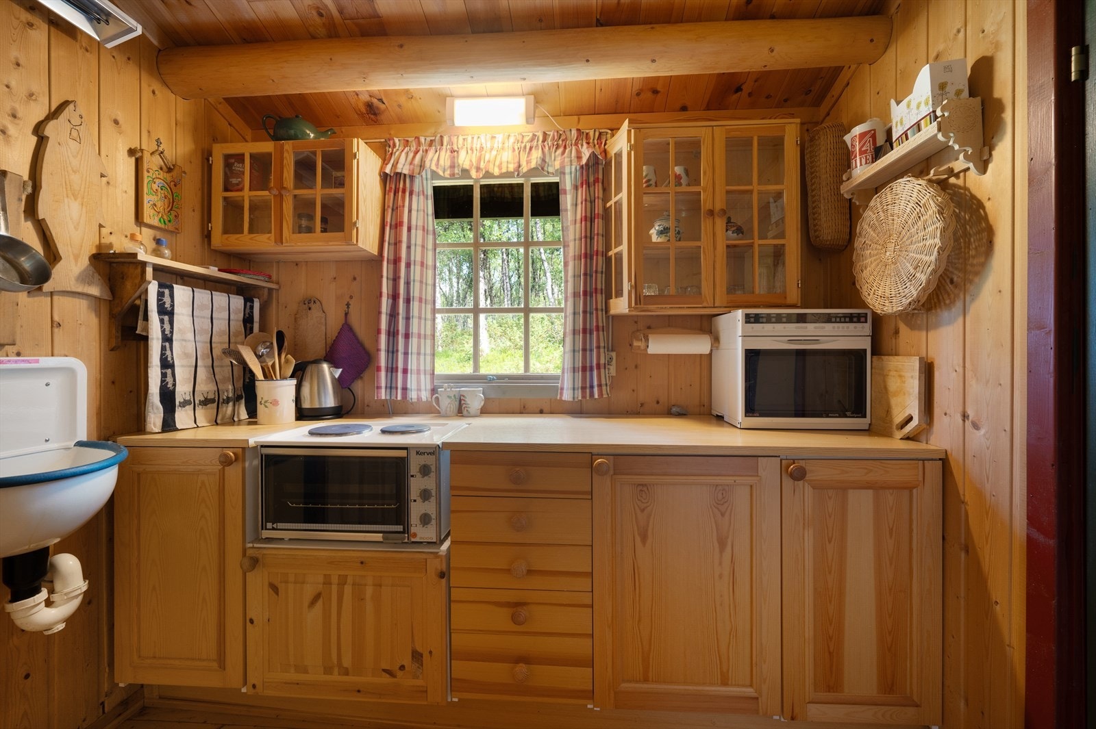 Innredningen er fra byggeår med enkel standard i laminat og heltre, det er montert en utslagsvask på siden. Galleribilde