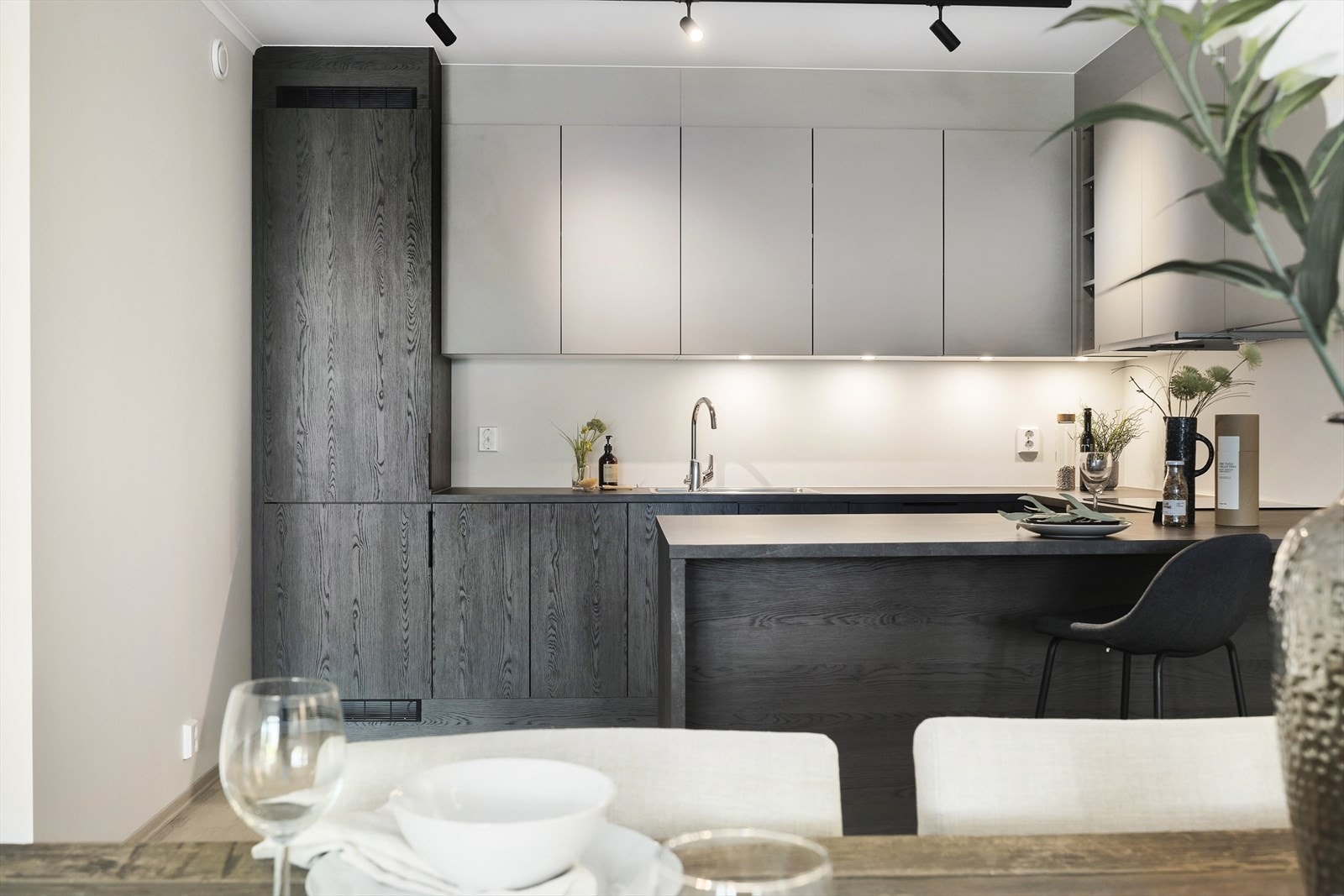 Kjøkkenet har delikate fronter, barløsning ved kjøkkenøyen og integrerte hvitevarer. Kjøkkenviften er oppgradert til en slim versjon som glir bedre inn i designet. Galleribilde