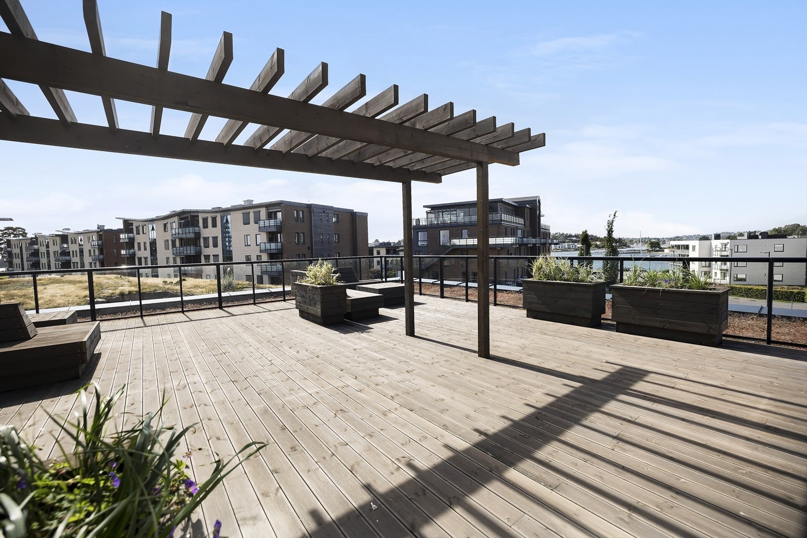 Ved å ta heisen opp i 4.etg er det en stor felles takterrasse. Her er det utstyrt med utekjøkken, benker og blomsterkasser. Utsikt til sjøen og gode solforhold. Galleribilde