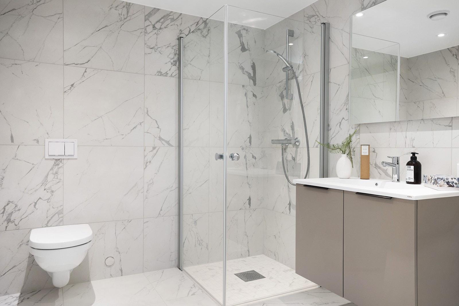 Delikat bad med fliser i marmoruttrykk. Varmekabler i gulv. Opplegg for vaskemaskin. Galleribilde