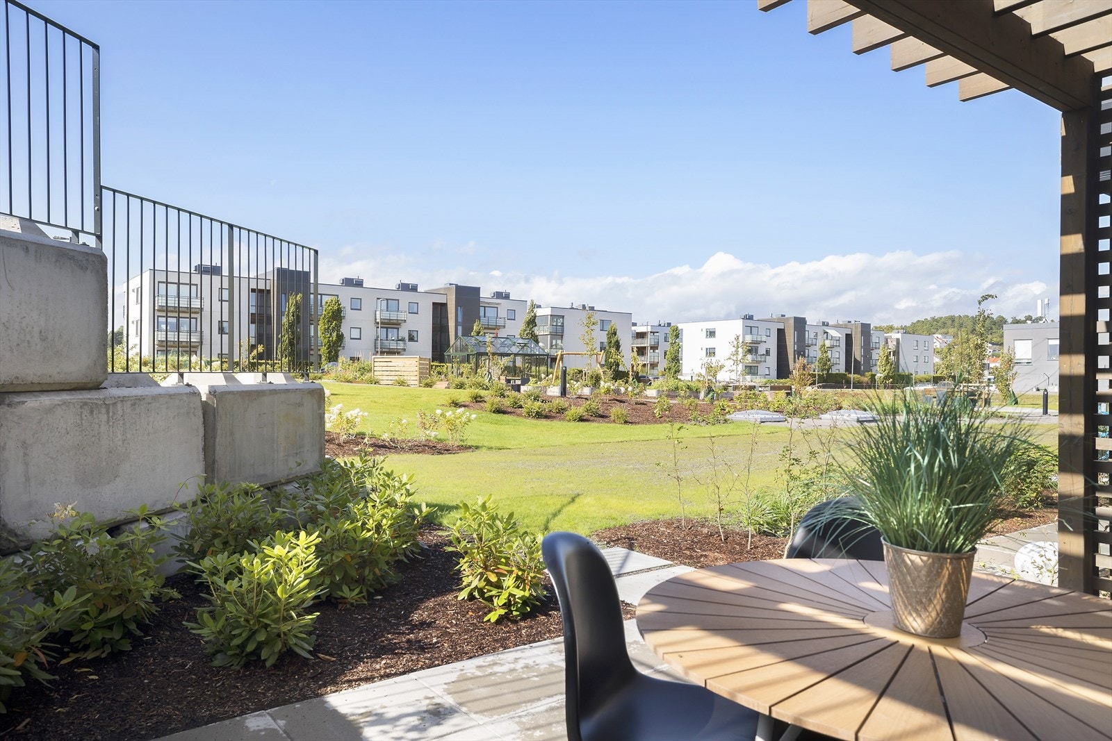 Det er bygget en flott pergola over den skjermede og solrike uteplassen - perfekt for en vakker klatreplante. Her er det fin utsikt, uten noen foran seg. Galleribilde