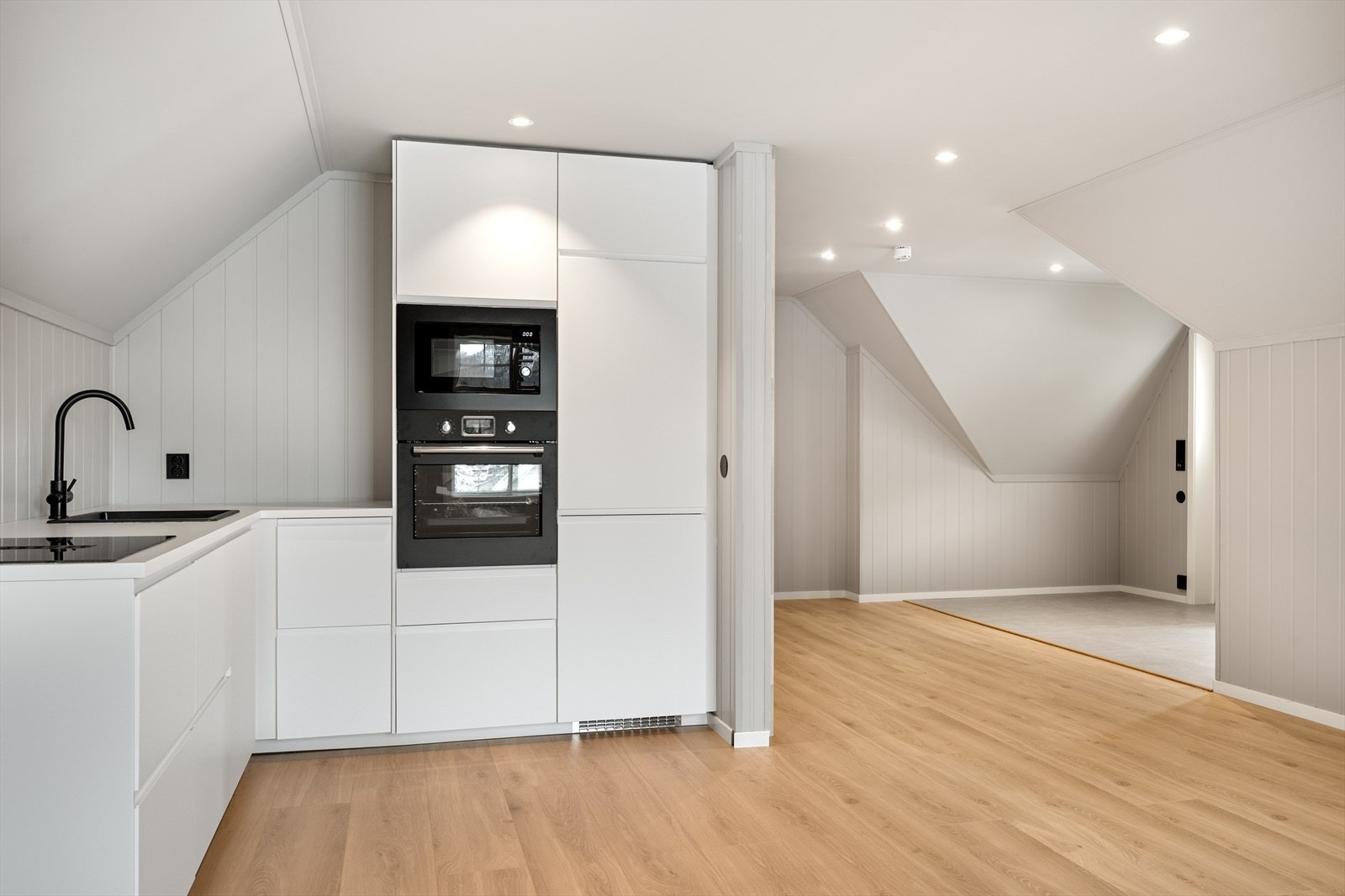 Lyst og stilrent kjøkken med integrerte hvitevarer. Det er åpen løsning mellom stue og kjøkken. Dette gir en god romfølelse. Galleribilde