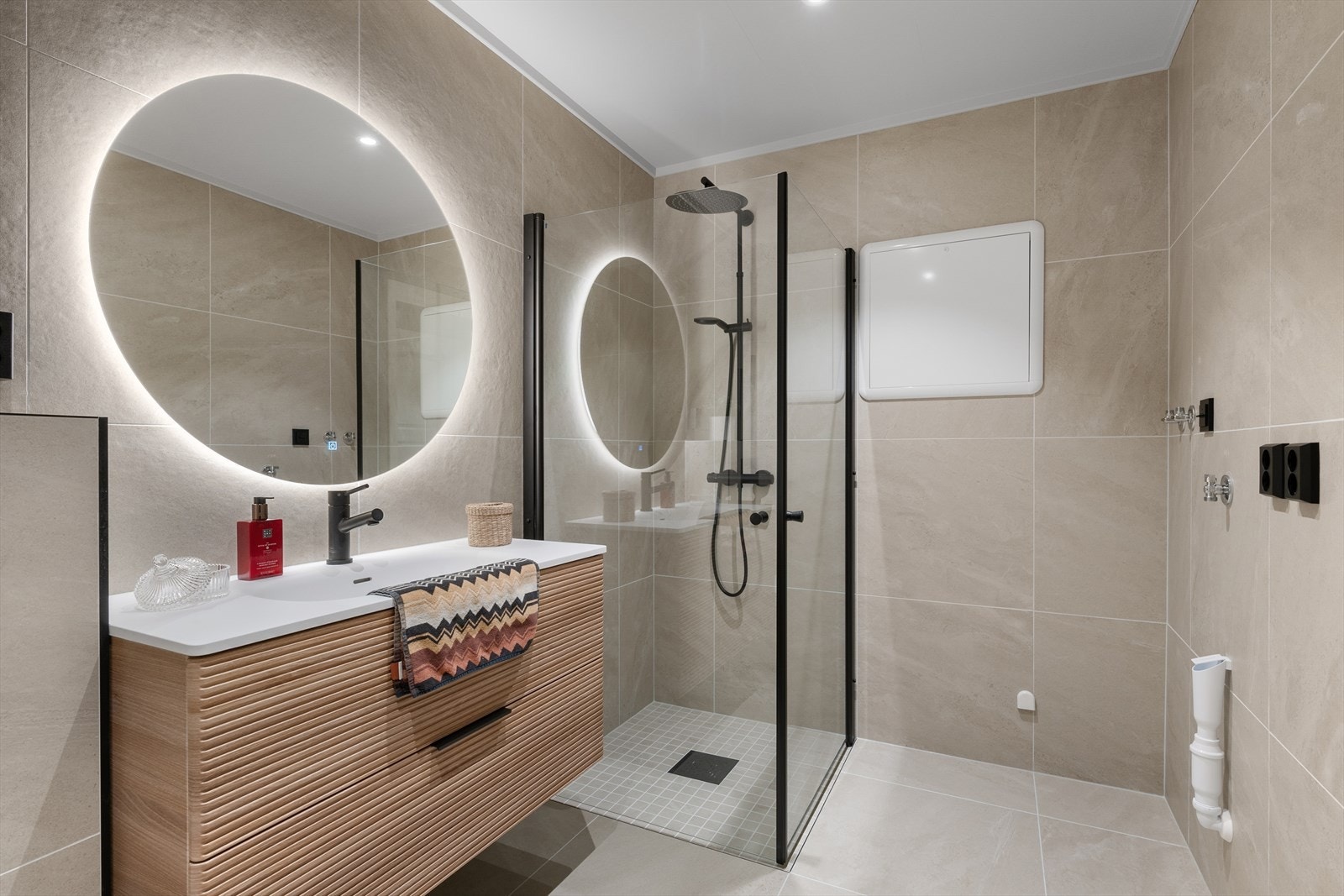 Badet består av toalett, servant med skuffer, dusj med innfellbare dusjdører og opplegg for vaskemaskin. Galleribilde