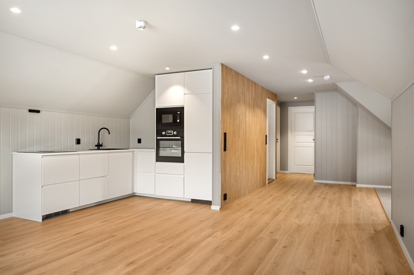 Spileveggen mellom gang og bad tilfører et moderne preg og skaper en kontrast til de ellers harmoniske fargetonene. Galleribilde