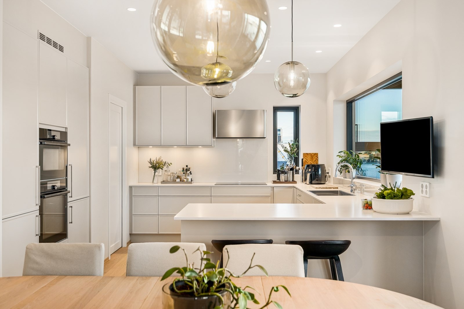 Flott, åpent og funksjonelt kjøkken fra Huseby. Røroshetta ventilator med Sense teknologi Galleribilde