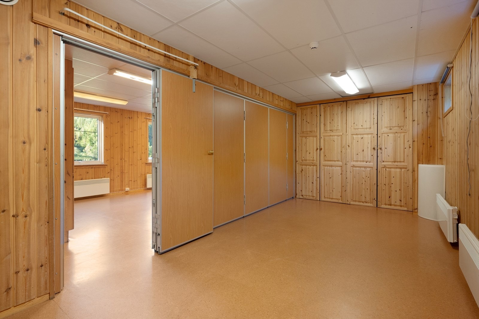 I motsatt ende av bygningen finner du to romslige oppholdsrom som er adskilt med skyvevegg. Galleribilde