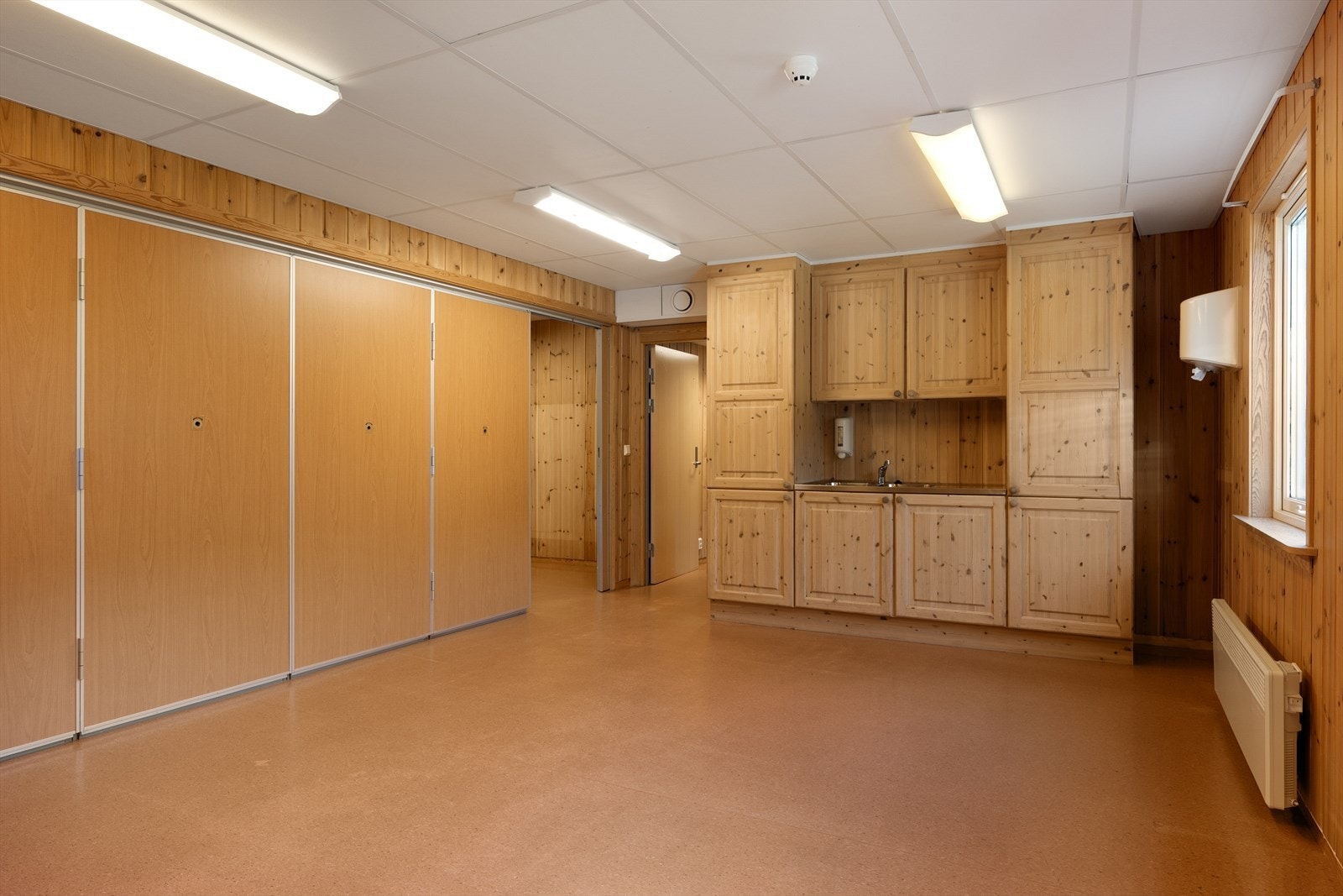 Det ene rommet er utstyrt med kjøkkeninnredning og kum. Galleribilde