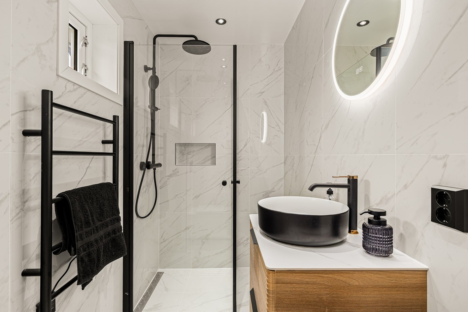 Rommet er innredet med dusjhjørne, møbel med toppservant, speil med lys og vegghengt klosett Galleribilde