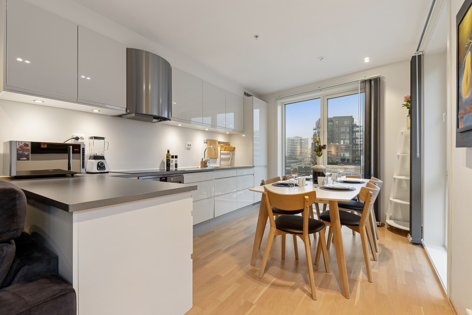 Kjøkkenet er lekkert, med hvite slette fronter og levert av kvalitetsleverandøren HTH. Her finner du integrerte hvitevarer, spot-/downlights under overskapene og en praktisk barløsning som gir ekstra arbeidsplass. Galleribilde