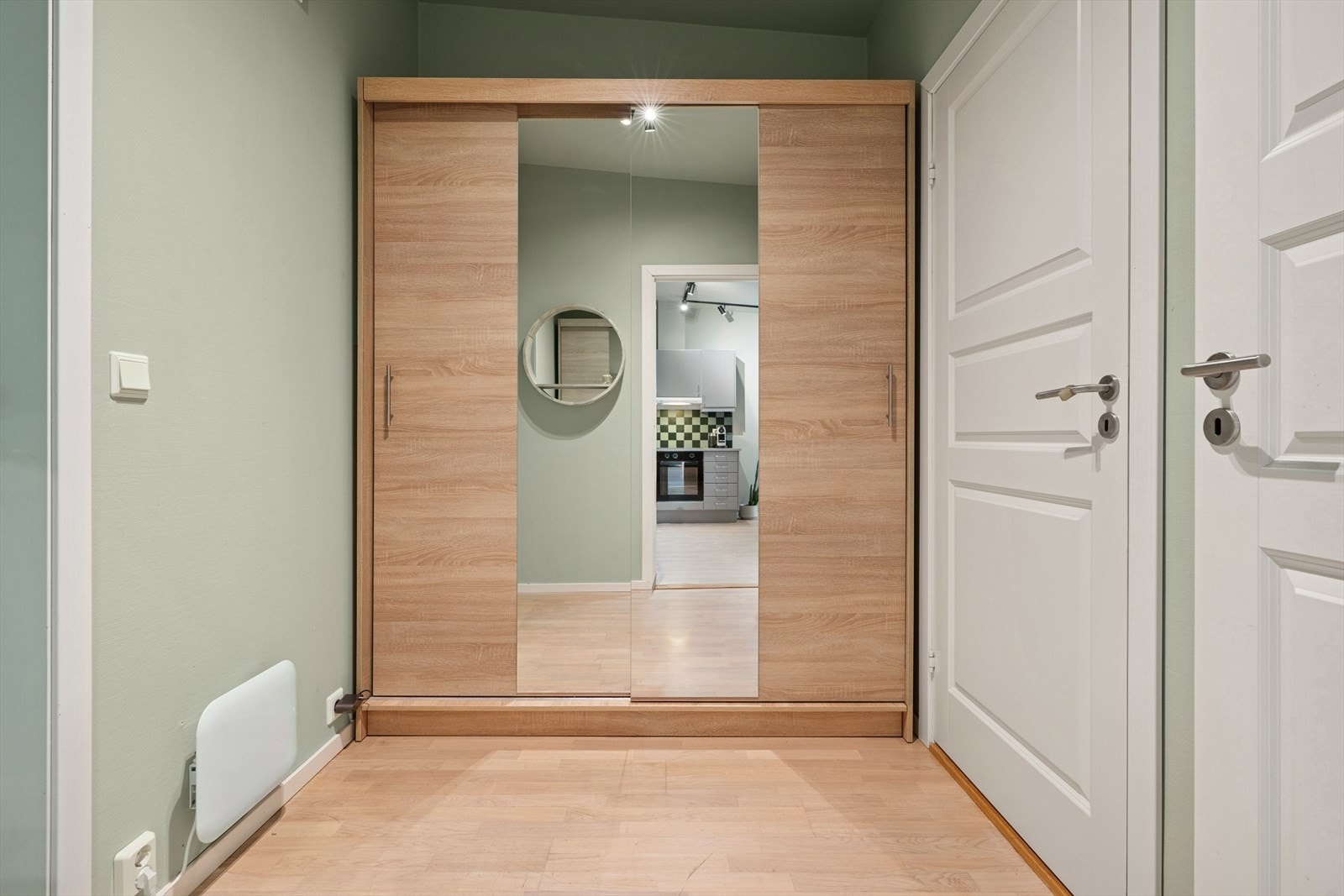 Leiligheten har adkomst via felles trappegang med heis, og du ønskes velkommen inn i en trivelig entré med parkettgulv og malte vegger i en dus fargetone Galleribilde