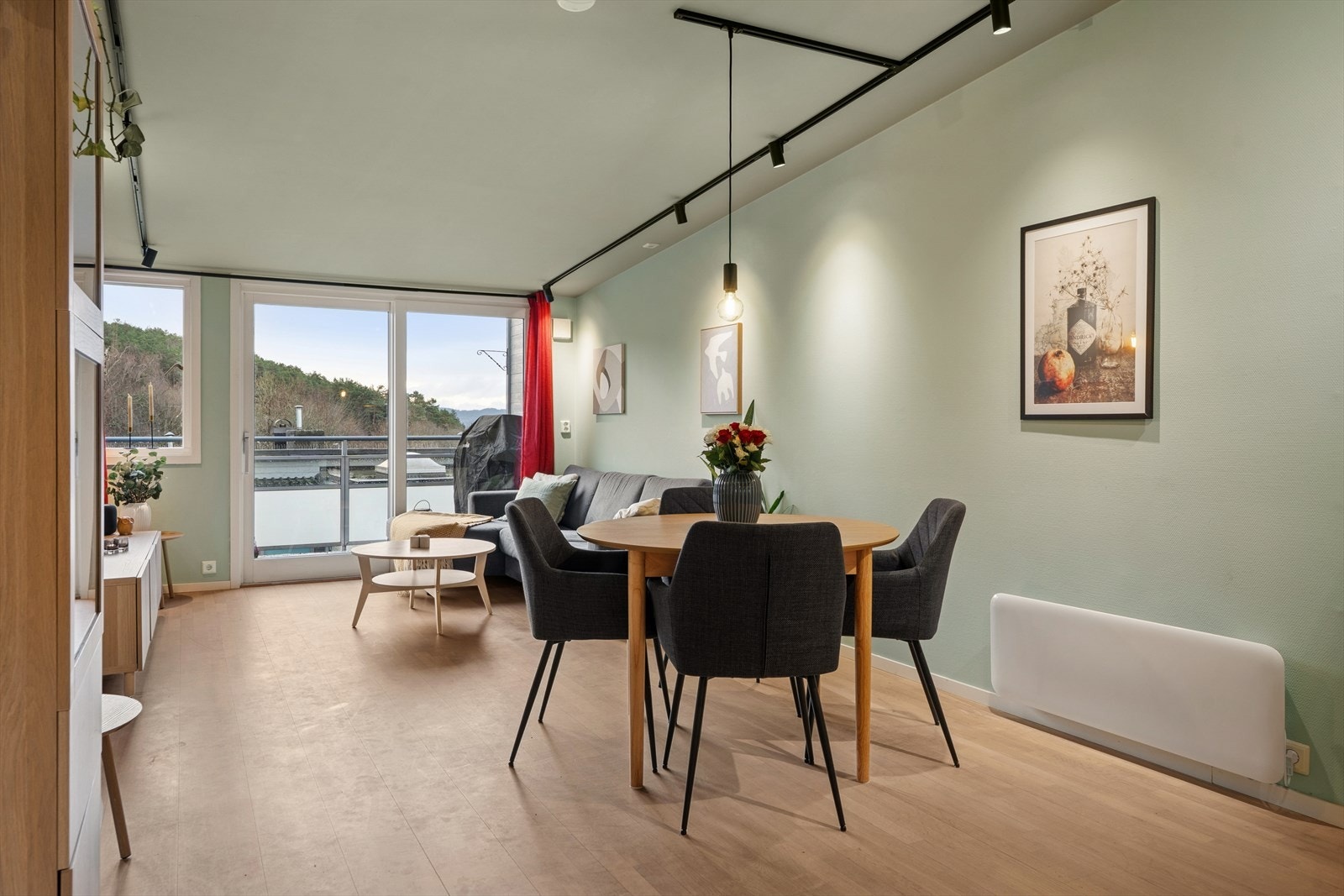 Parkettgulvet fra entréen videreføres her, og store vindusflater sammen med terrassedøren slipper inn rikelig med naturlig lys Galleribilde