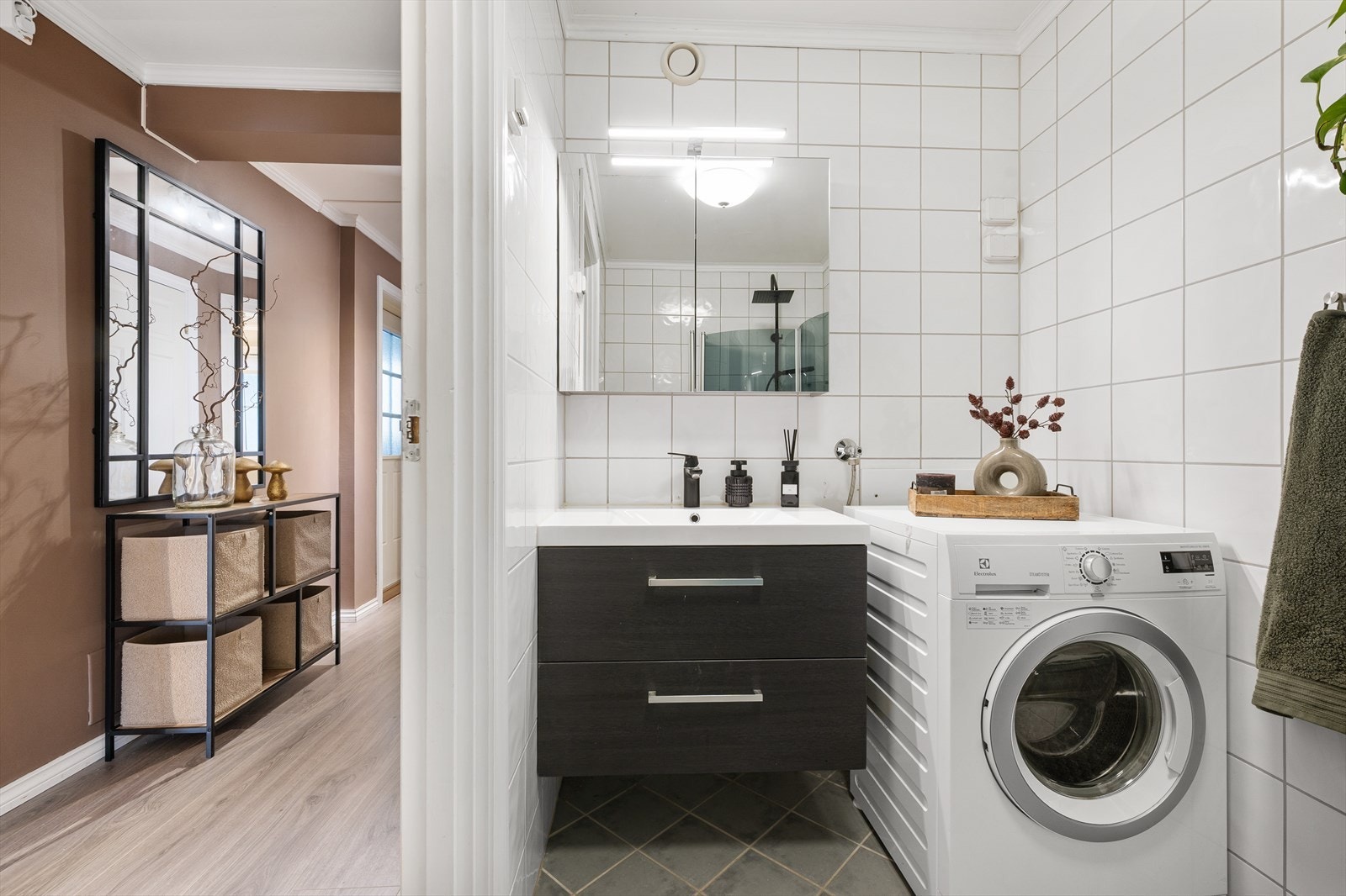 Helfliset bad som har sorte fronter og består av en heldekkende servant på en skuffeseksjon og et dobbelt speilskap. Galleribilde