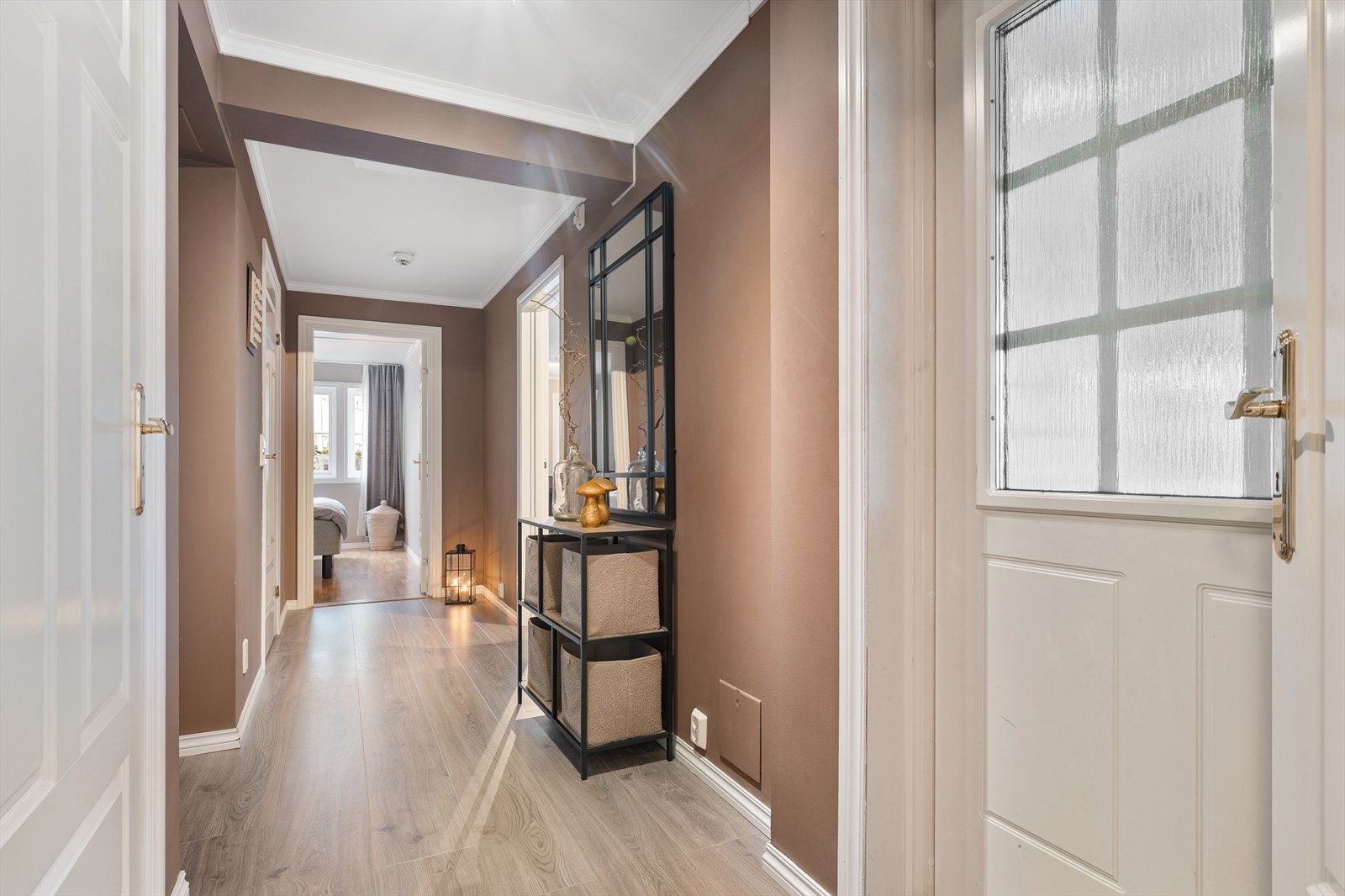 Boligen har en hvit ytterdør med kodelås og frostet glassfelt. Galleribilde