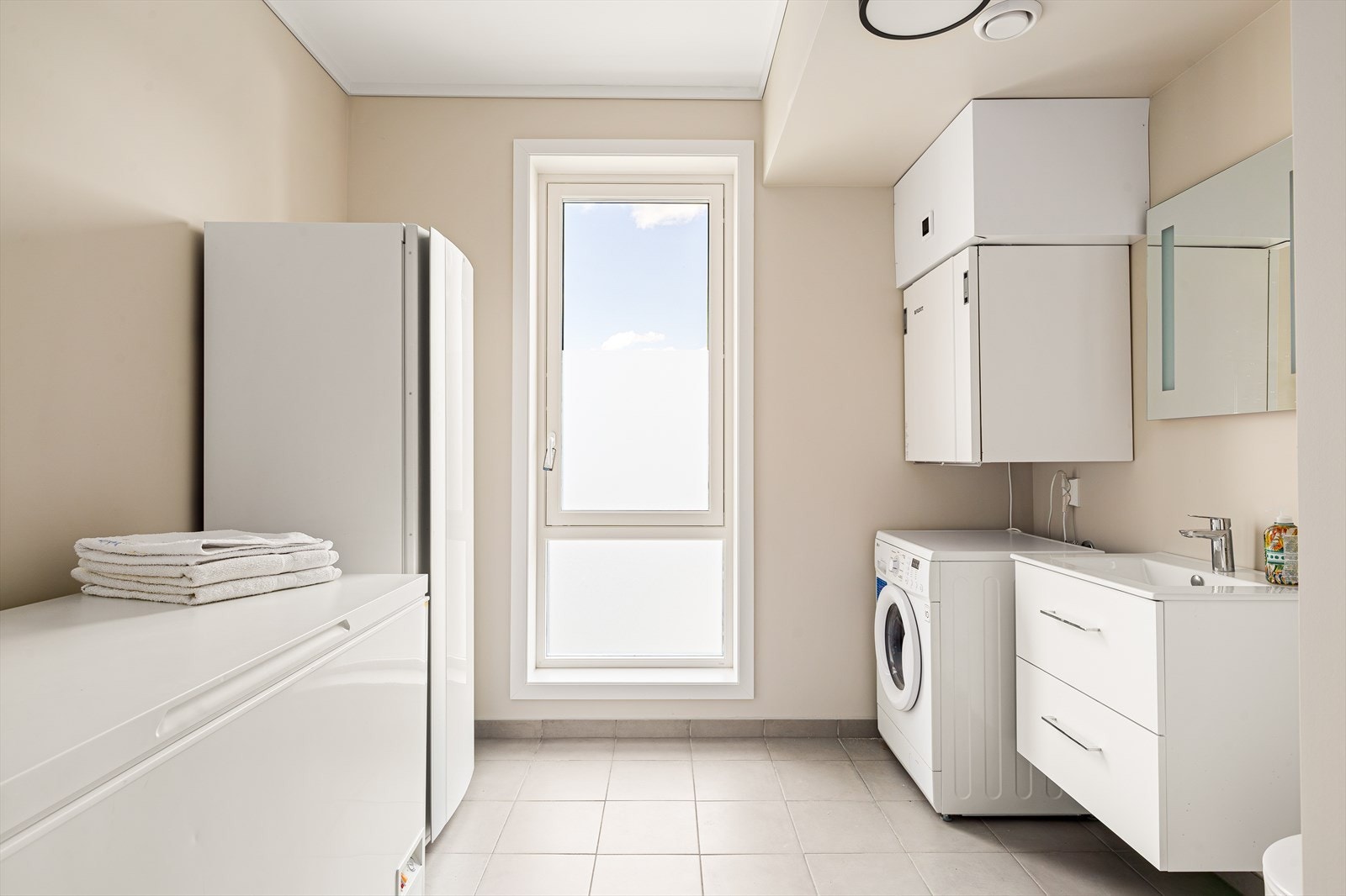 Det er opplegg for vaskemaskin, og rommet er godt tilrettelagt for effektiv klesvask og organisering. Et praktisk og stilrent rom med høy nytteverdi. Galleribilde