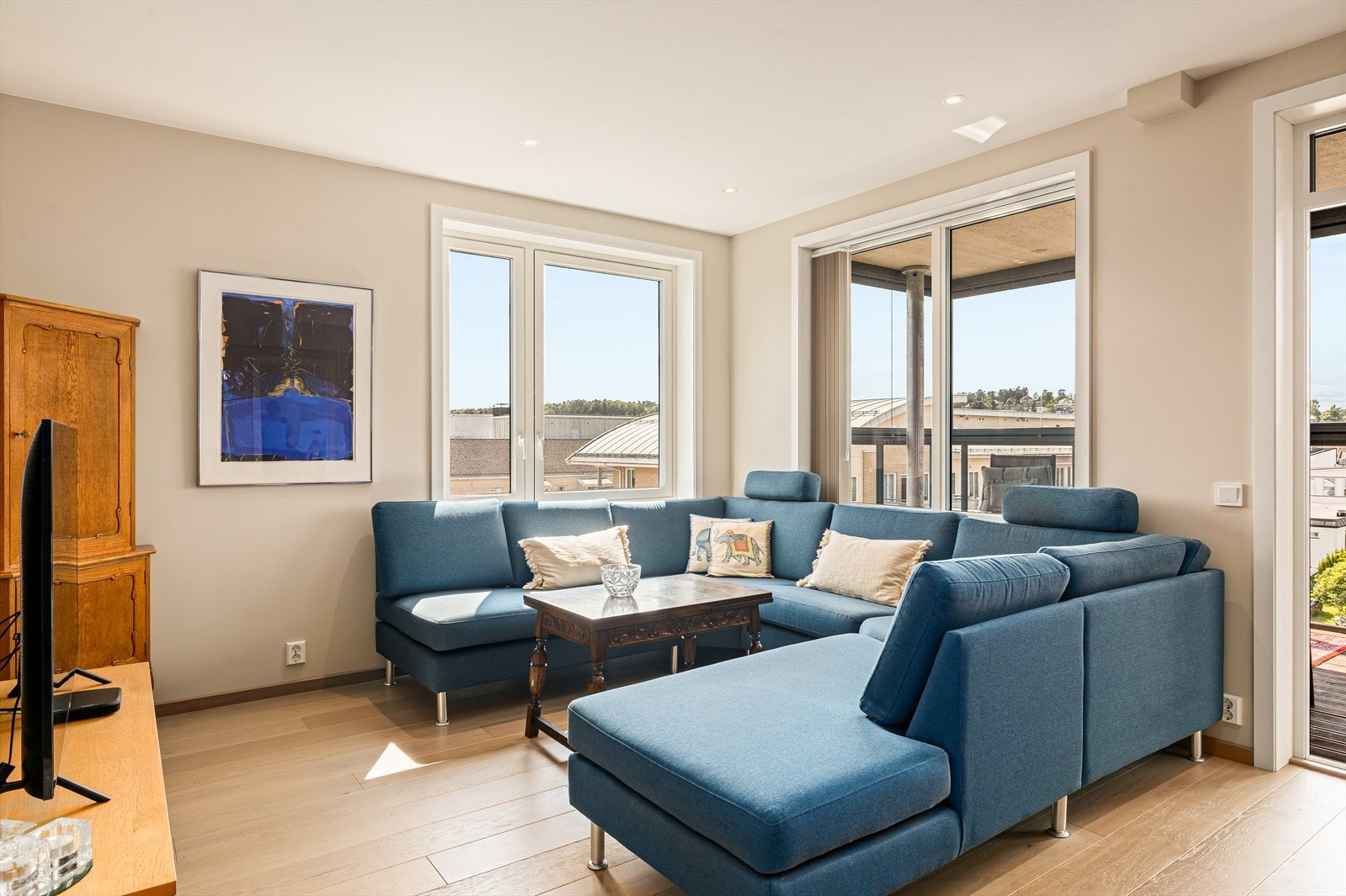 Rommet har en god størrelse og en smart utforming som gjør det enkelt å møblere med både en stor sofagruppe og spiseplass for familie og gjester. Galleribilde