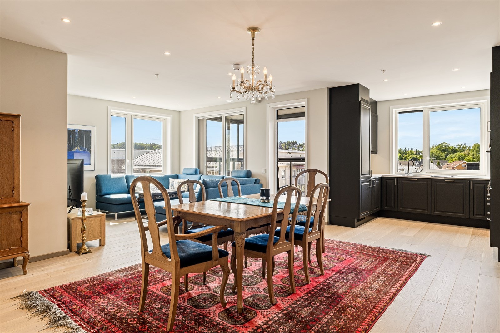 Vel inne i stuen møtes du av et romslig og lyst oppholdsrom hvor store vindusflater slipper inn rikelig med naturlig dagslys og skaper en luftig og behagelig atmosfære. Galleribilde