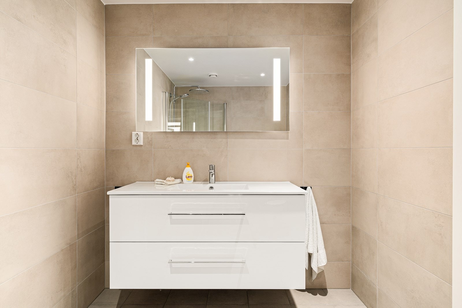 Badet er helfliset med lekre farger som gir rommet et stilrent og samtidig varmt uttrykk. Her er det lagt vekt på både estetikk og funksjon, med gjennomtenkte materialvalg og en behagelig atmosfære. Galleribilde