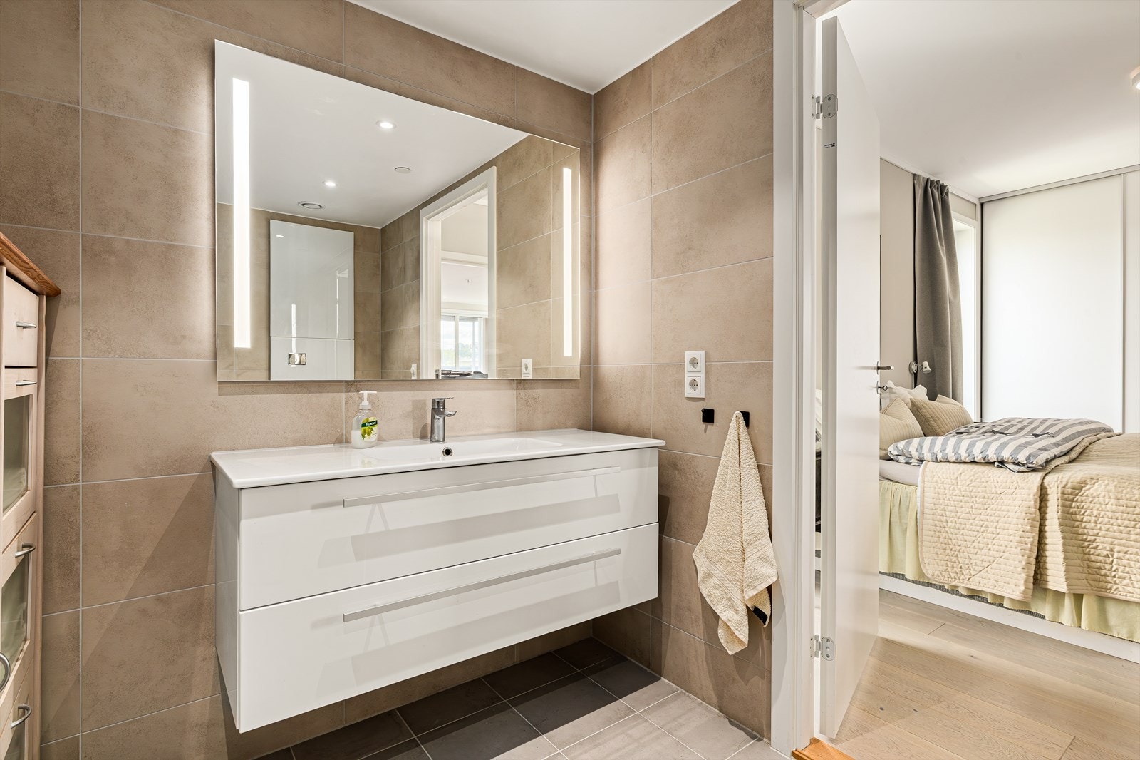 Et ekstra pluss er den direkte tilgangen til eget baderom - en luksuriøs og praktisk løsning som gir en suite-følelse og øker bokomforten betraktelig. Her får du et rom som kombinerer funksjon, komfort og estetikk - perfekt som et personlig fristed. Galleribilde