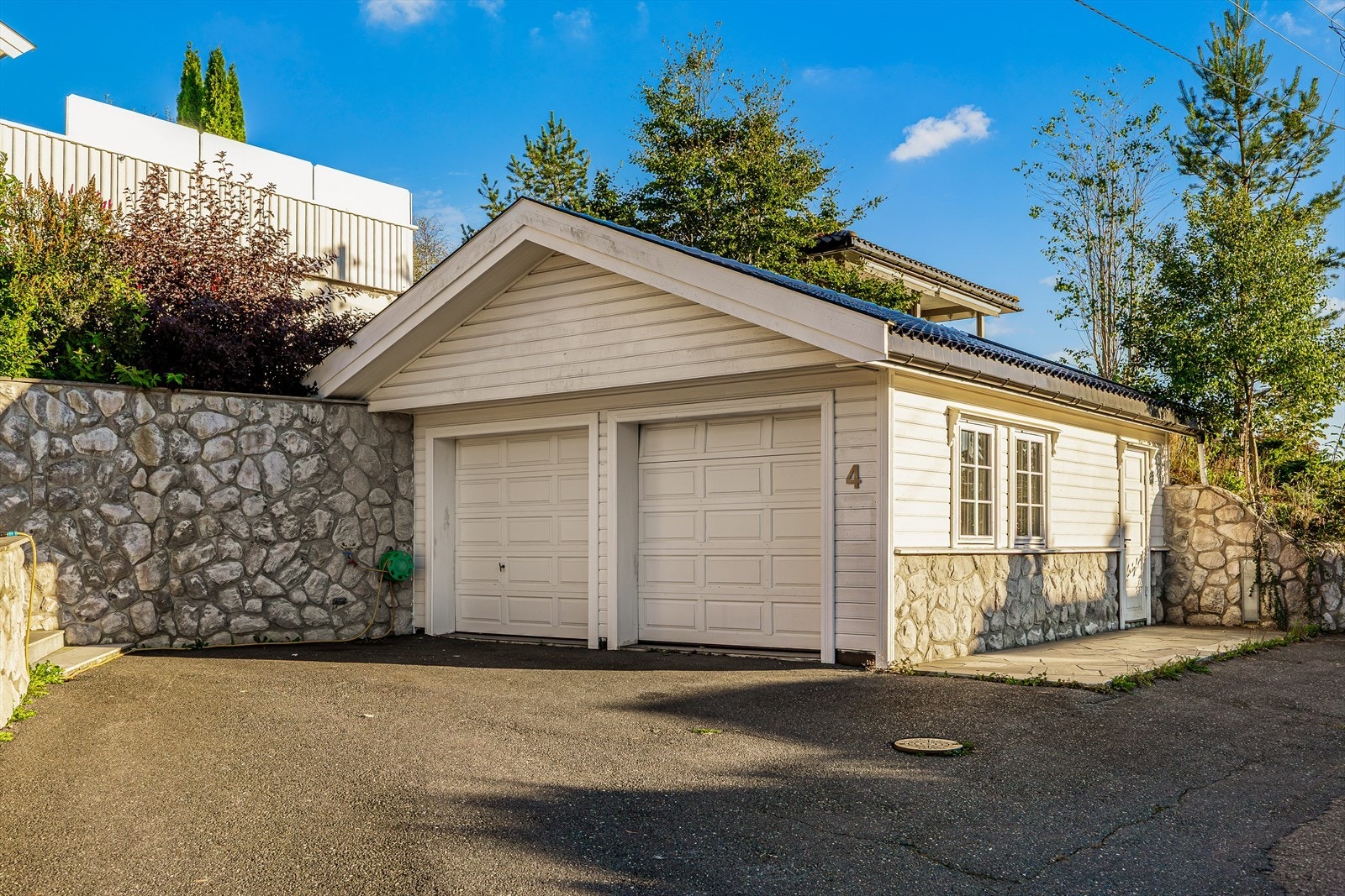 Dobbelgarasje fra 2000 med god plass, flislagt gulv, varmekabler og praktisk loft - en gjennomført løsning som kombinerer komfort, funksjonalitet og lagringsmuligheter. Galleribilde