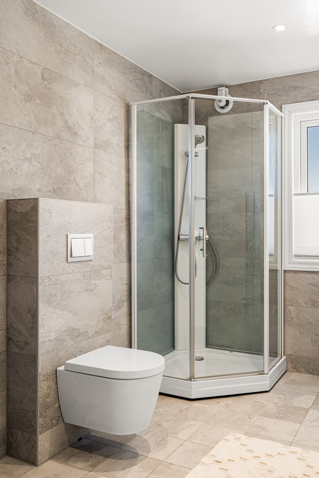 Badet er oppgradert med behagelig gulvvarme som gir komfort året rundt, og er innredet i en moderne og tidløs fargepalett med lyse flater og elegante kontraster. Den gjennomførte stilen skaper en rolig og innbydende atmosfære, Galleribilde