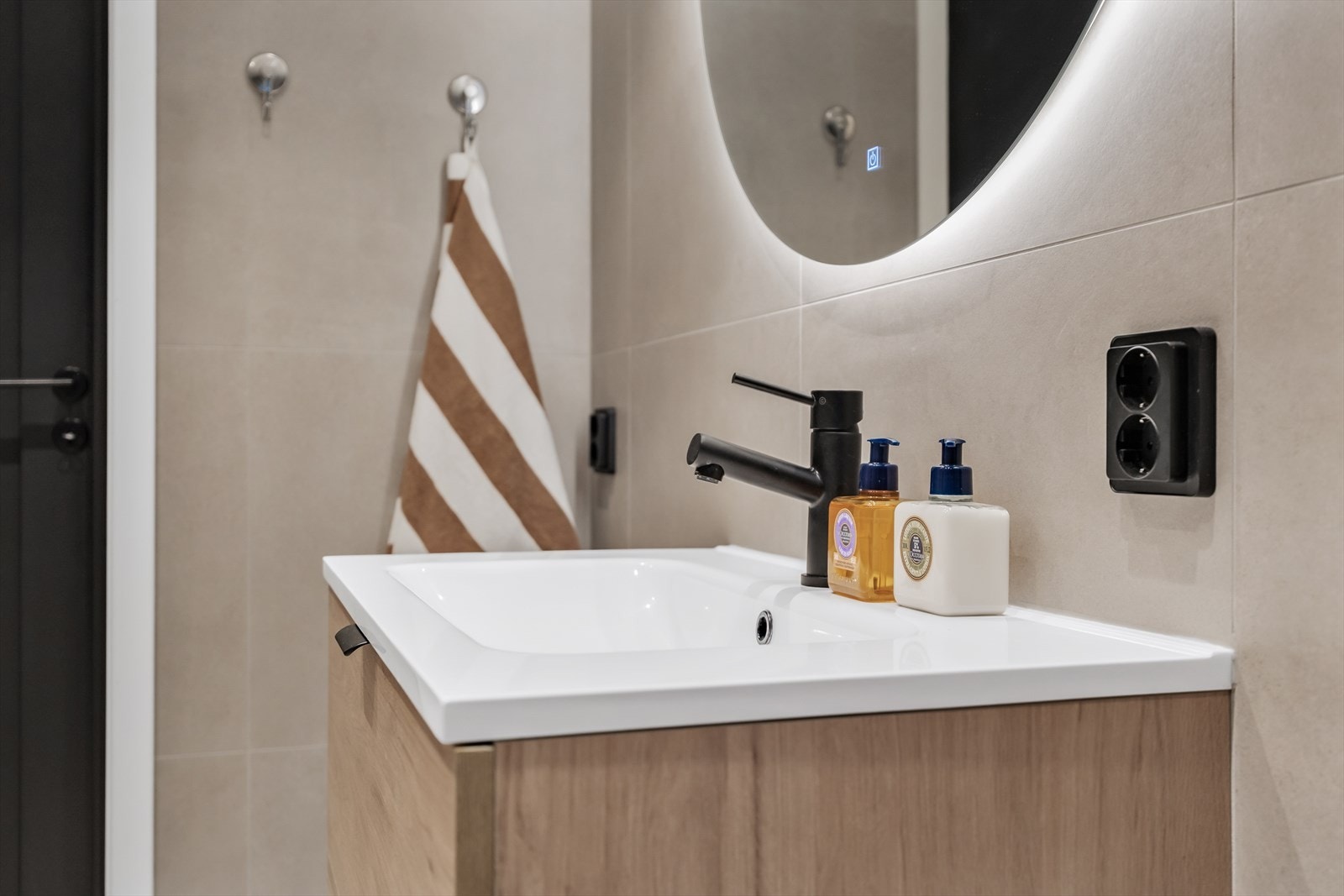 Innredningen består av en formstøpt servant med skuffer og moderne, sorte armaturer. Galleribilde