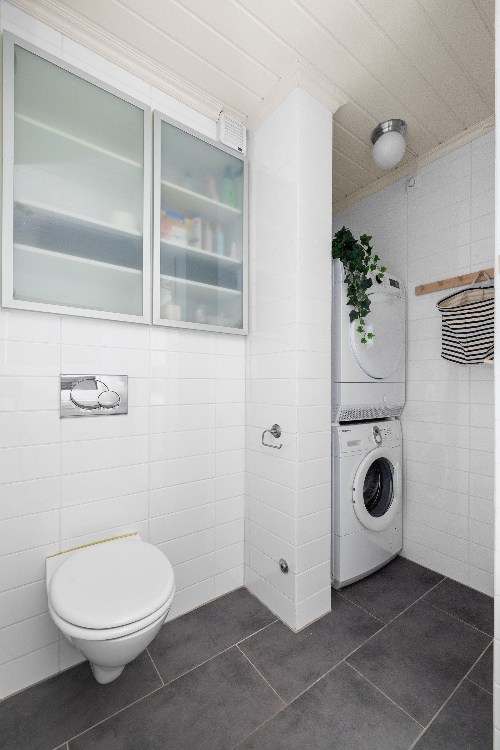 Badet har godt med oppbevaringsplass og en egen nisje med opplegg til vaskemaskin og tørketrommel Galleribilde