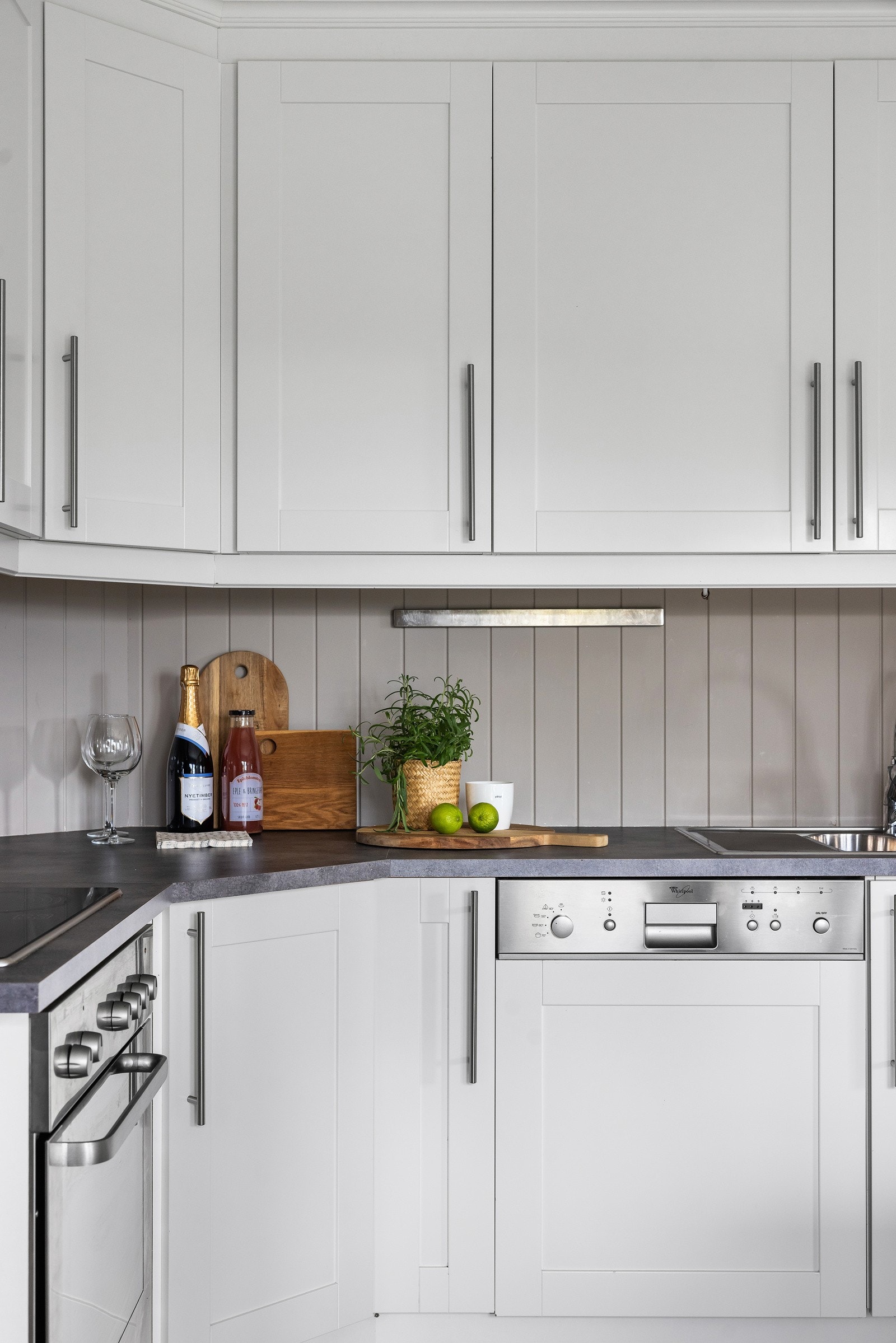 Innredningen har hvite, profilerte fronter og benkeplate i laminat Galleribilde