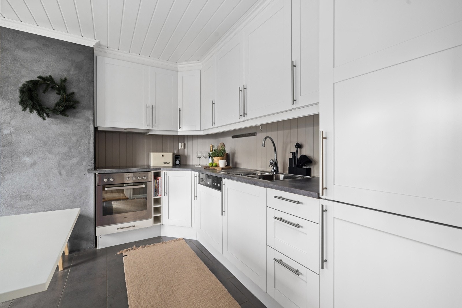 Kjøkkenet har hvitevarer som kjøleskap med frysedel, stekeovn, platetopp og oppvaskmaskin Galleribilde