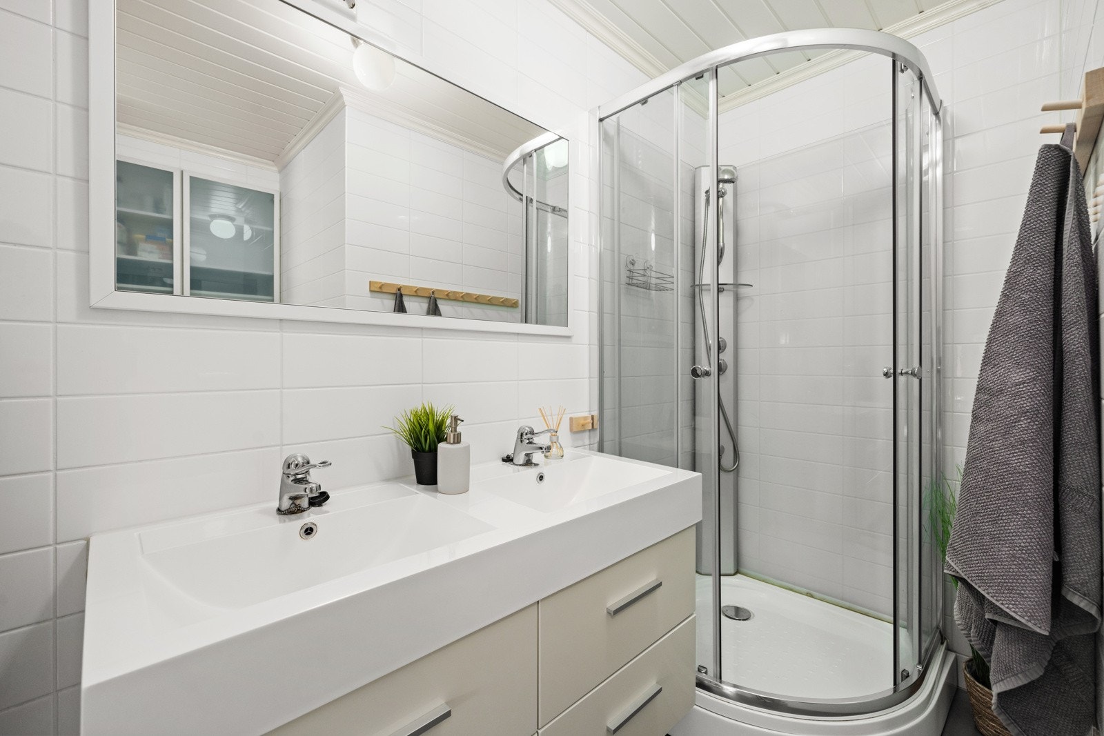 Badet innehar vegghengt toalett, dusjkabinett og dobbel servant med stilig skuffeseksjon Galleribilde