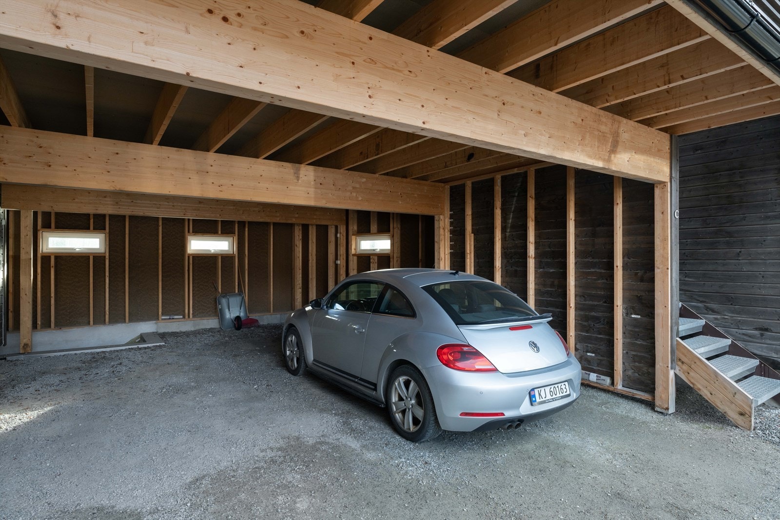 Biloppstillingsplass i carporten og nedgang til venstre ned til bod/teknisk rom i kjeller Galleribilde