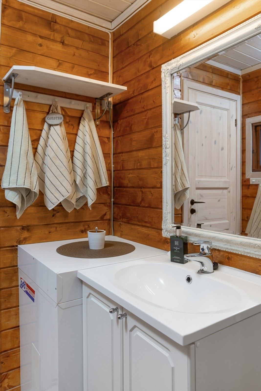 Baderommet er innredet med servantinnredning, speil over servanten, dusjnisje og gulvmontert toalett. Galleribilde