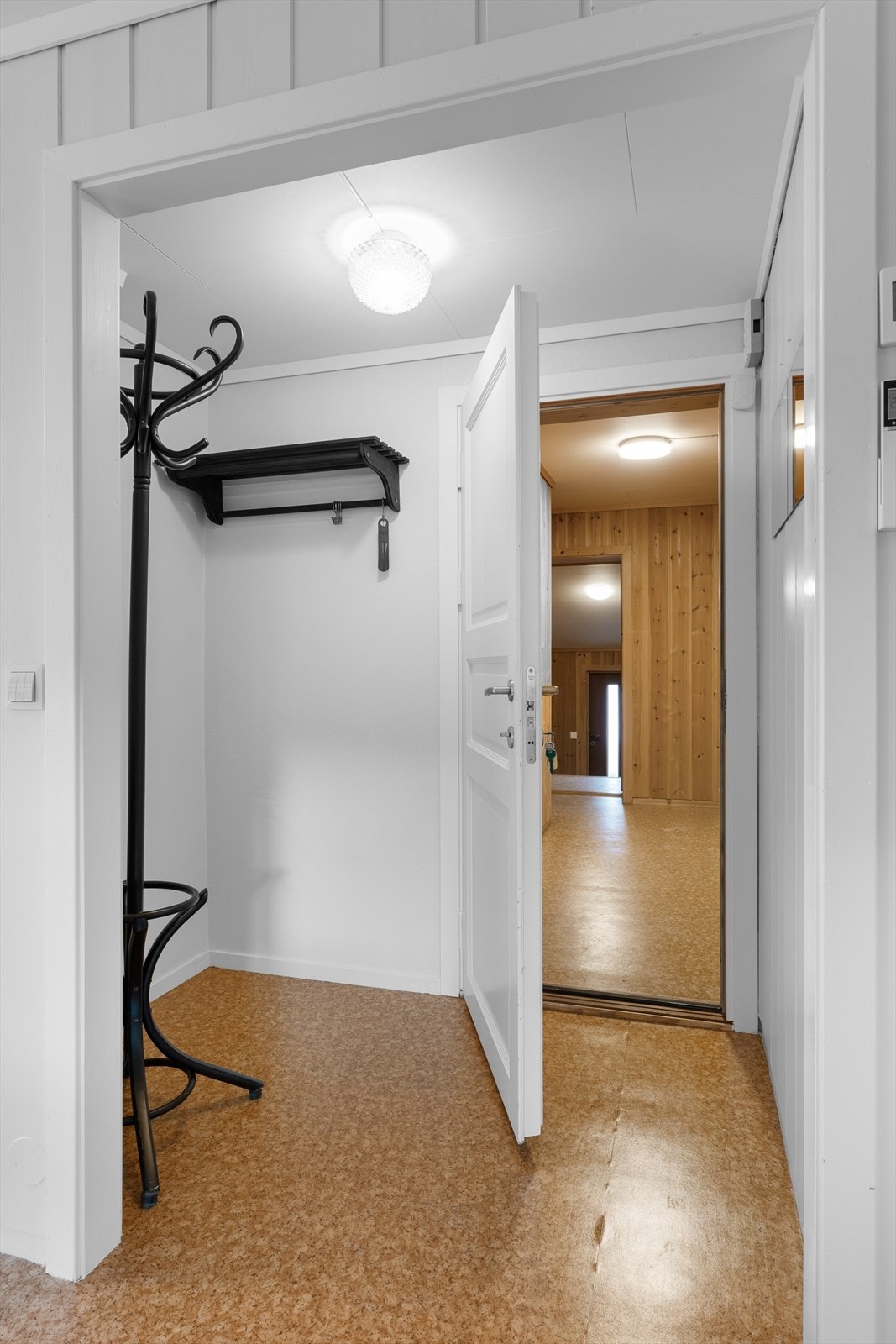I den lyse entréen er det en liten nisje med plass til klær og sko. Galleribilde