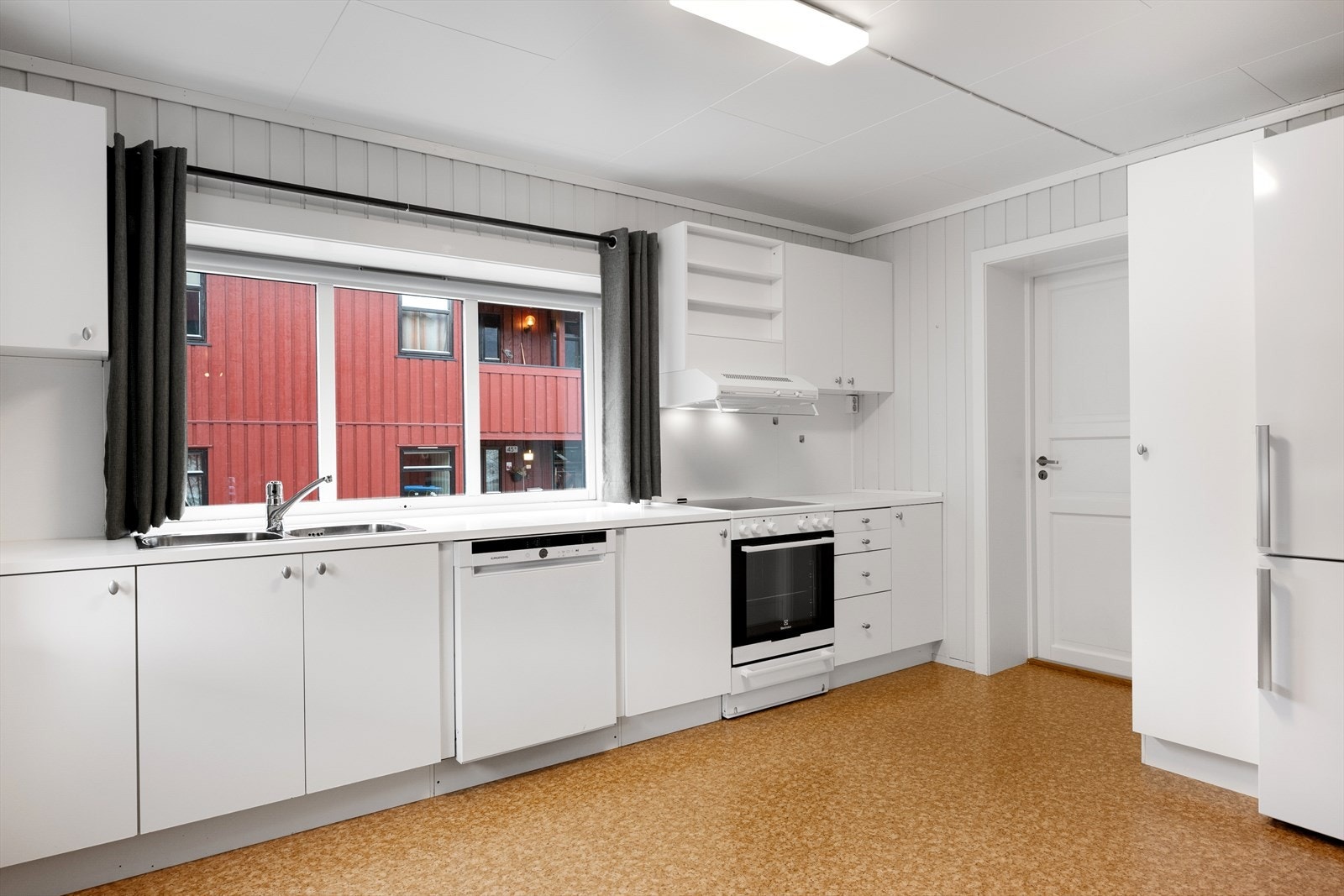 Kjøkkenet har frittstående hvitevarer, dobbel stålkum og opplegg for oppvaskmaskin. Galleribilde