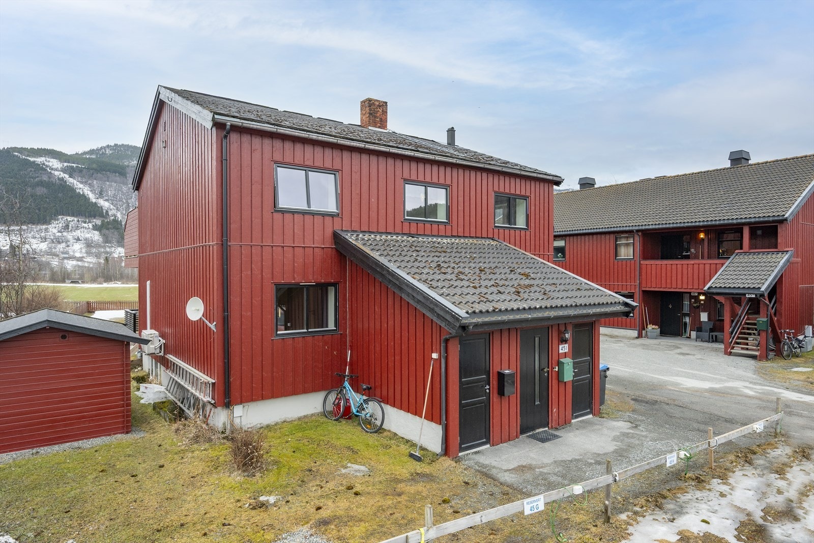 Inngang fra bakkeplan med trapp inn til leiligheten. Galleribilde