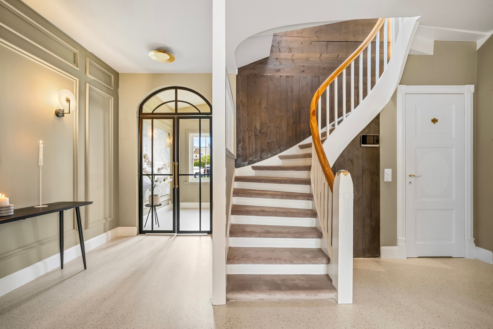 Trappen er elegant og hvitmalt med teppelagte trinn og trehvit håndløper. Galleribilde