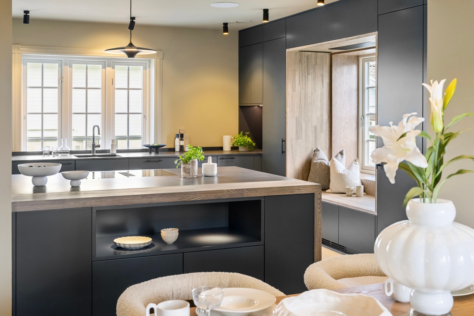 Kjøkkeninnredningen er av høy kvalitet og består av en langstrakt benk montert langs vinduene, en stor kjøkkenøy i overgangen til spisestuen, et smalt høyskap på siden og to brede, innfelte høyskapsmoduler. Galleribilde