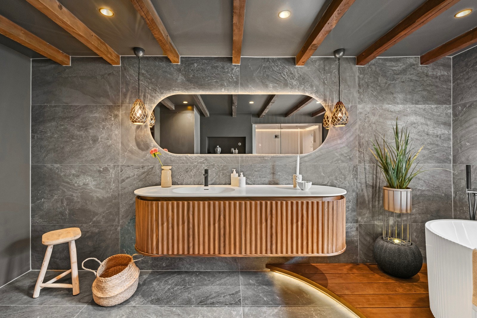 To vegger og gulv er dekket av gråmarmorerte storformatfliser, brutt opp av skipsgulv i innerste del og en gråmalt rillevegg. Galleribilde